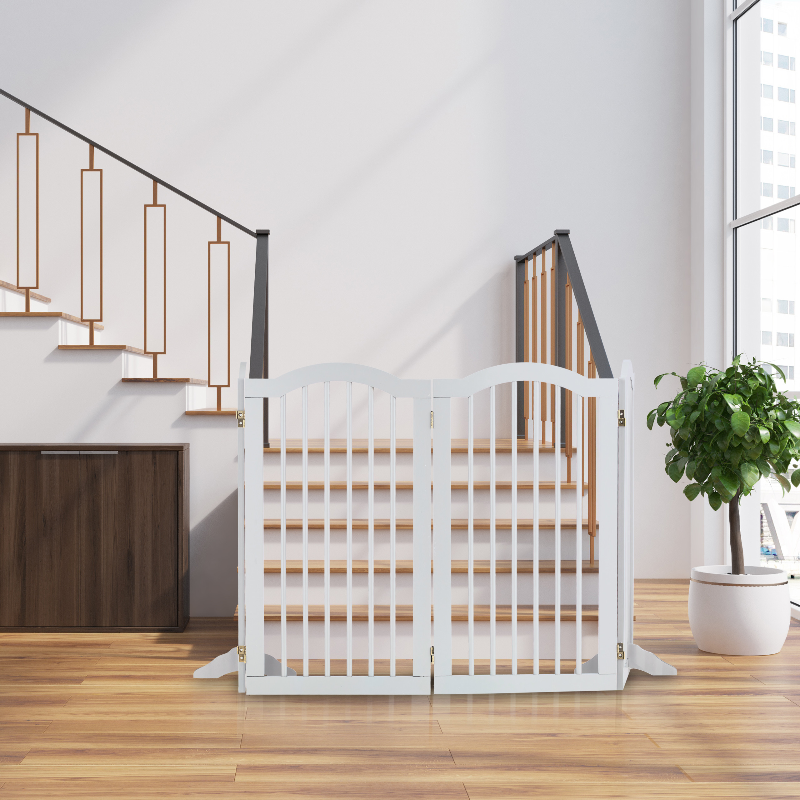 Ein weißes Babygitter steht am Fuß einer Holztreppe in einem hellen Raum.