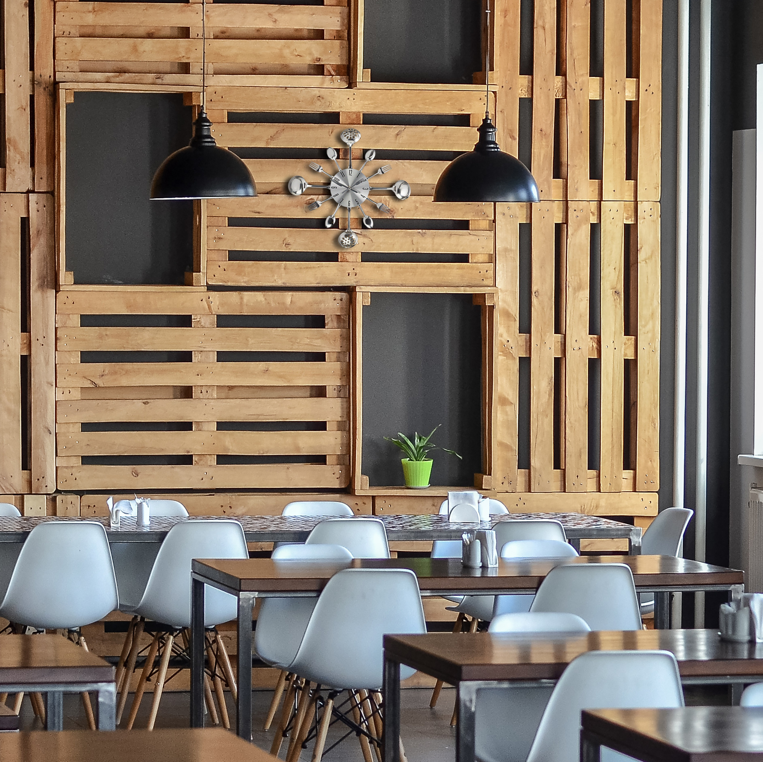 Ein Café mit Holzwänden, schwarzen Pendelleuchten und weißen Stühlen an Tischen.