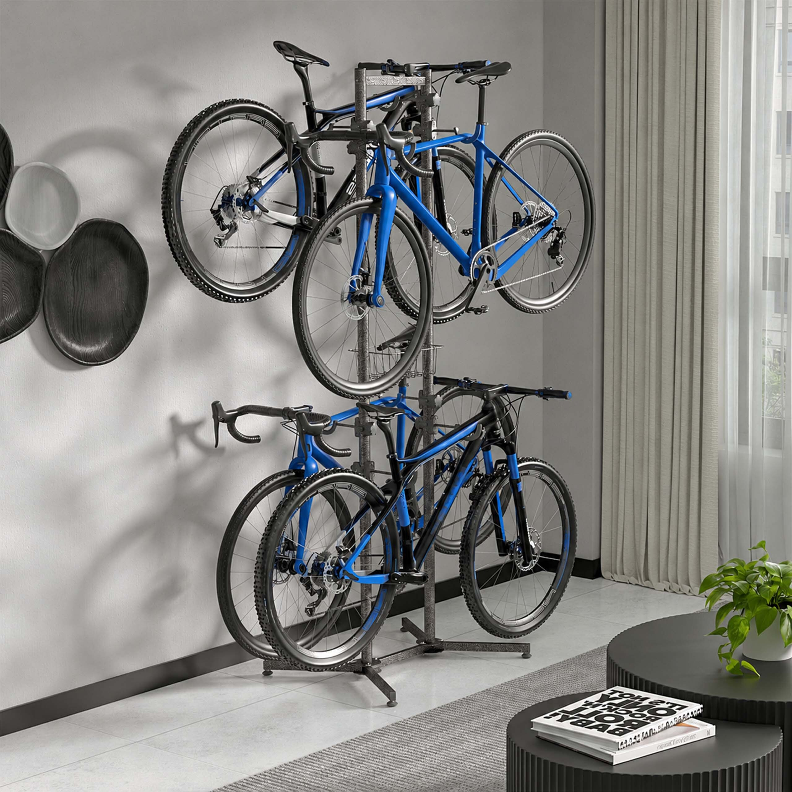 Ein grauer Fahrradständer an einer Wand hält vier blaue und schwarze Fahrräder in einem modernen Raum.