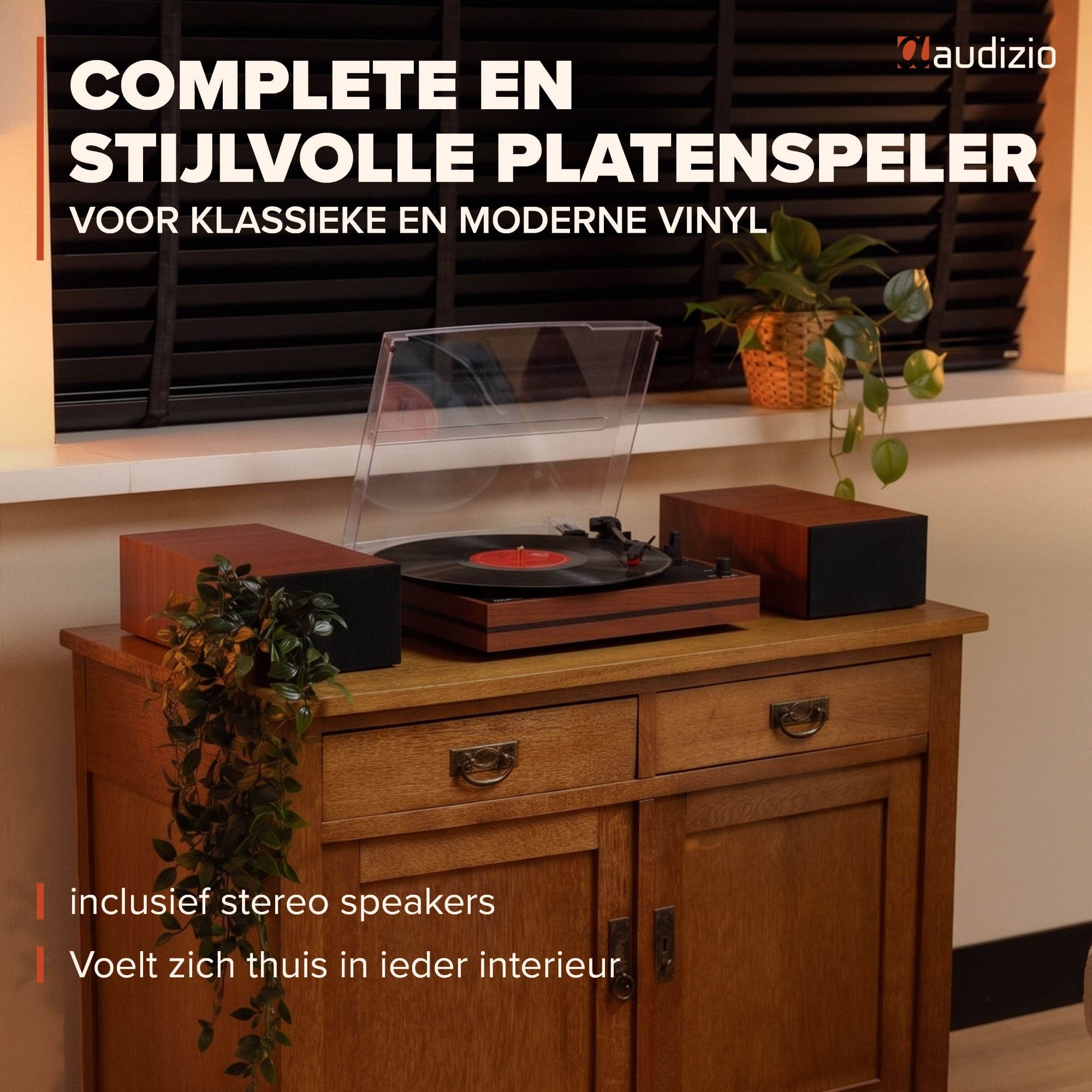Un tocadiscos de madera con dos altavoces sobre un armario frente a una ventana.