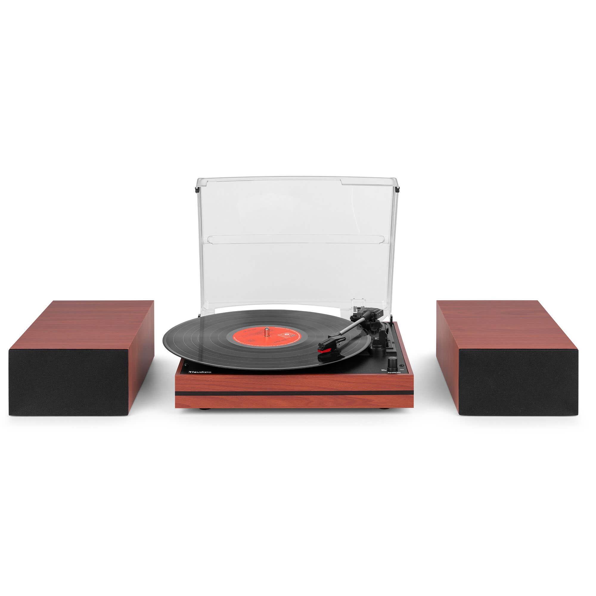 Un tocadiscos de madera con cubierta acrílica abierta, flanqueado por dos altavoces de madera a juego sobre fondo blanco.
