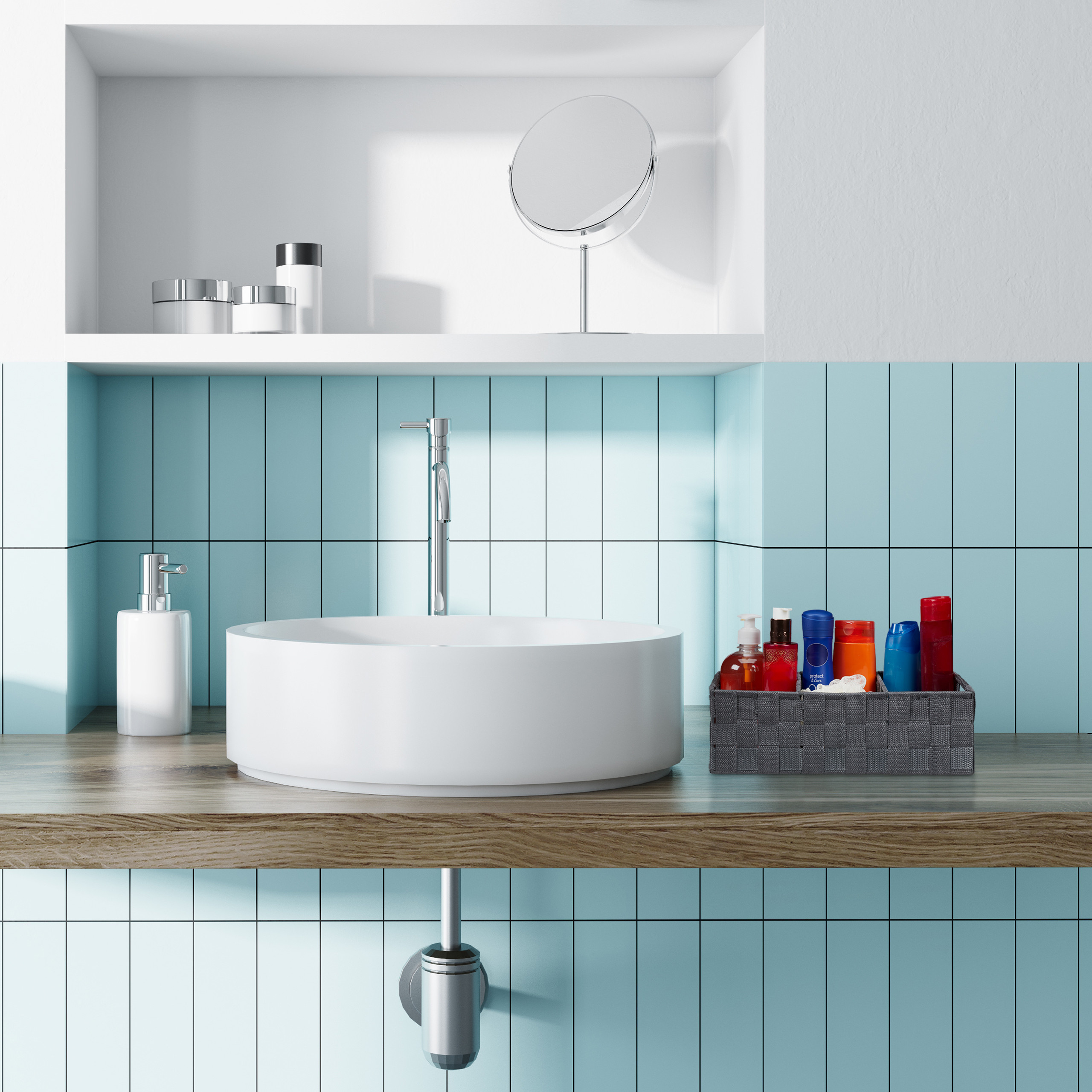 Ein weißes rundes Waschbecken auf einer Holzplatte mit blauen Fliesen, Chromarmatur, Seifenspender und Korb.