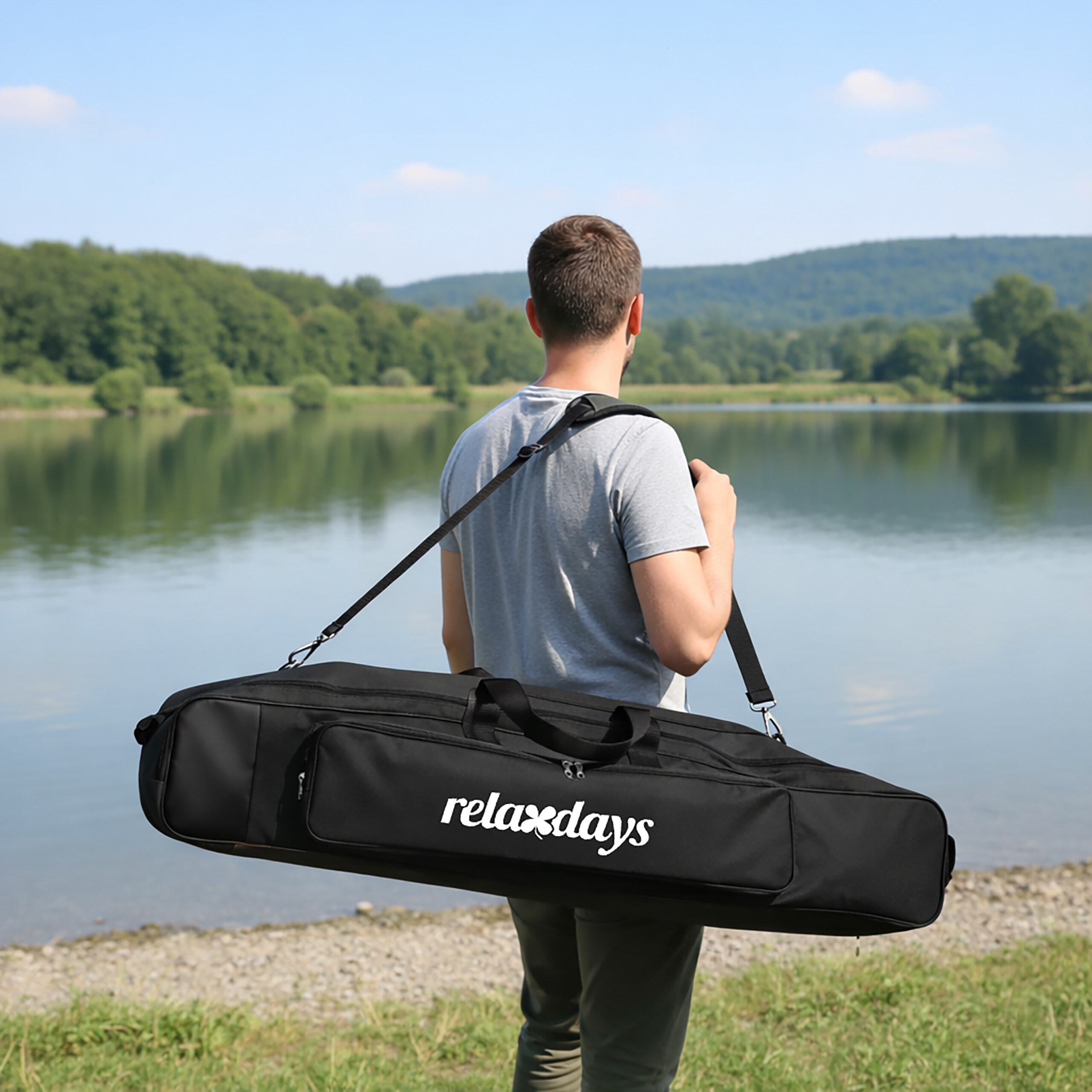 Ein Mann trägt eine schwarze Relaxdays Tasche an einem See.