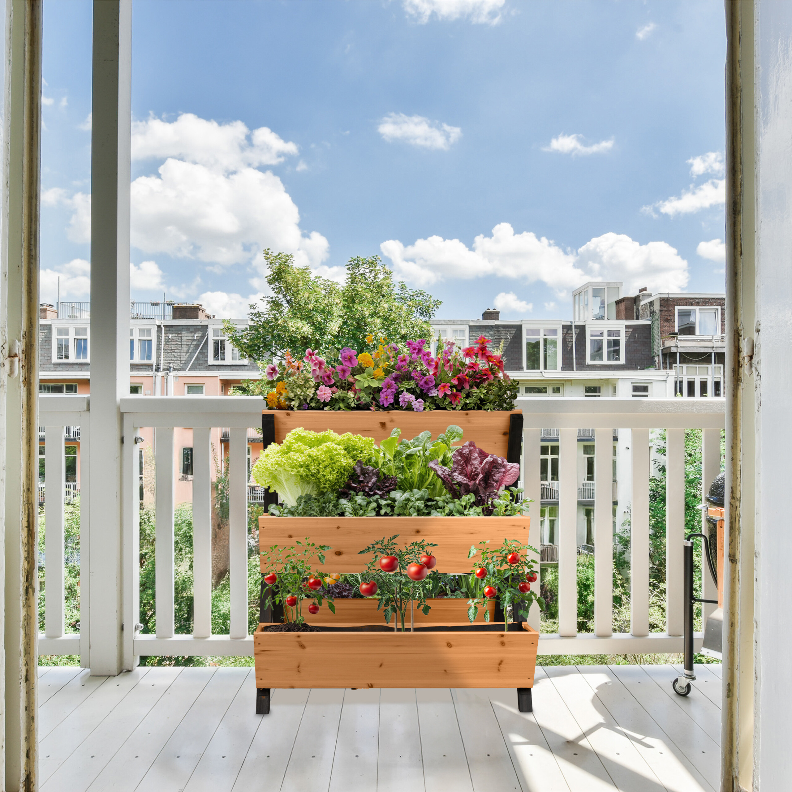 Ein hölzernes vertikales Gartenbeet gefüllt mit Blumen, Salat und Tomatenpflanzen auf einem sonnigen Balkon.