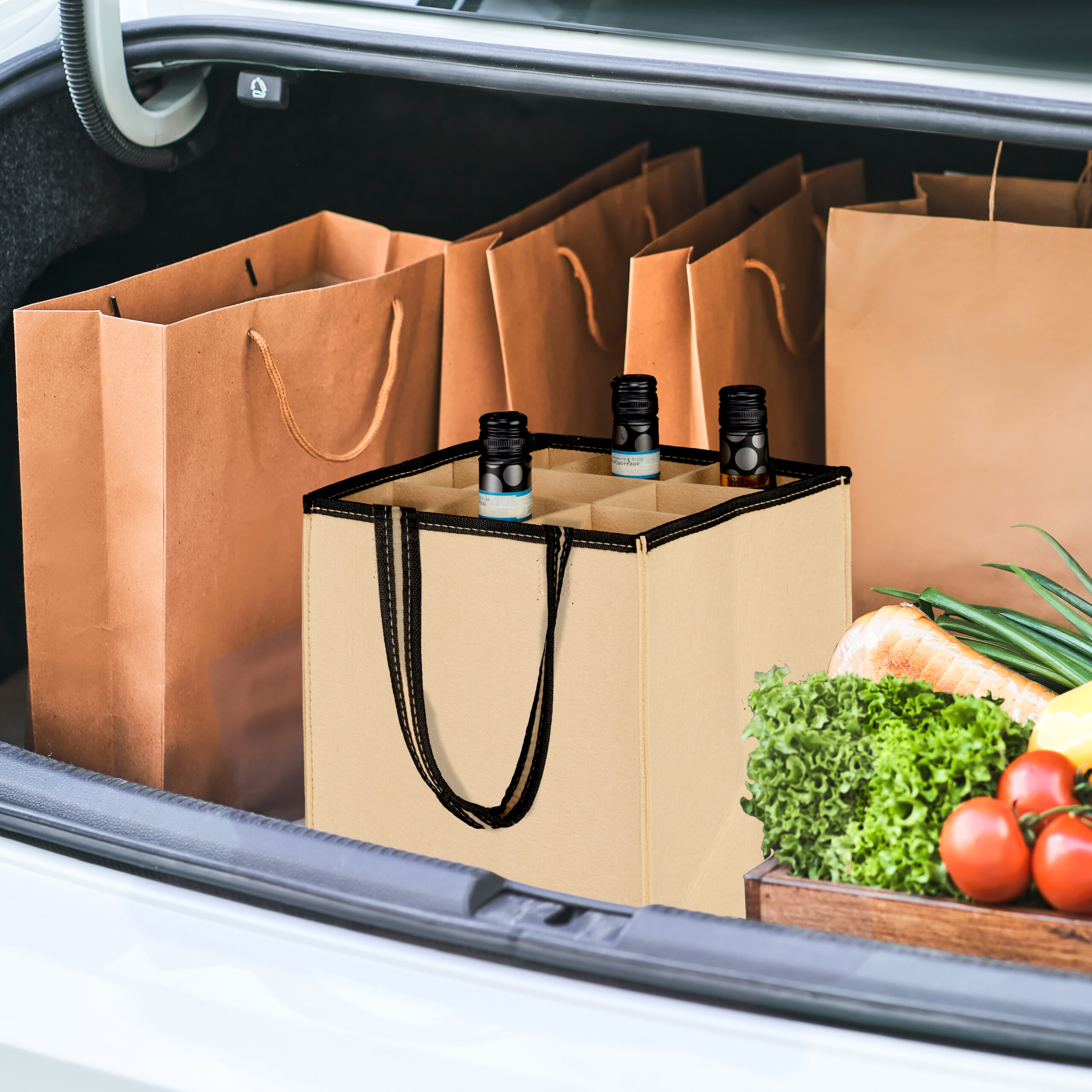 Eingekaufte Waren und Weinflaschen stehen im offenen Kofferraum eines Autos.
