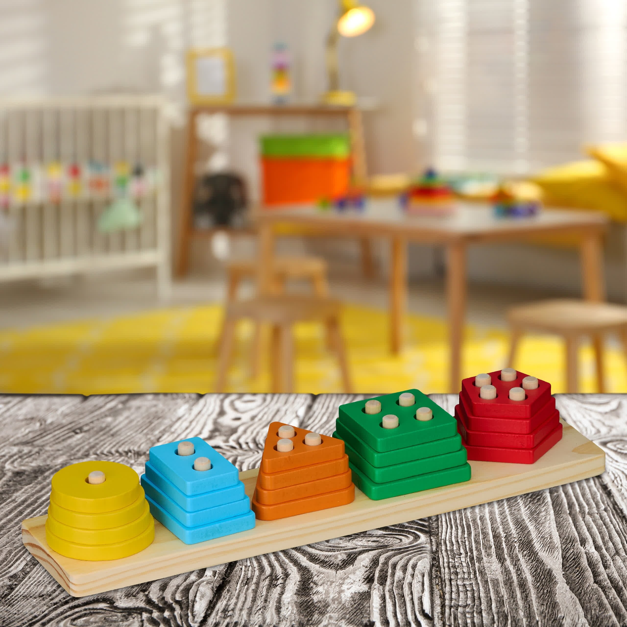 Buntes Holz-Steckspiel mit gelben, blauen, orangen, grünen und roten Formen auf einem Holztisch.