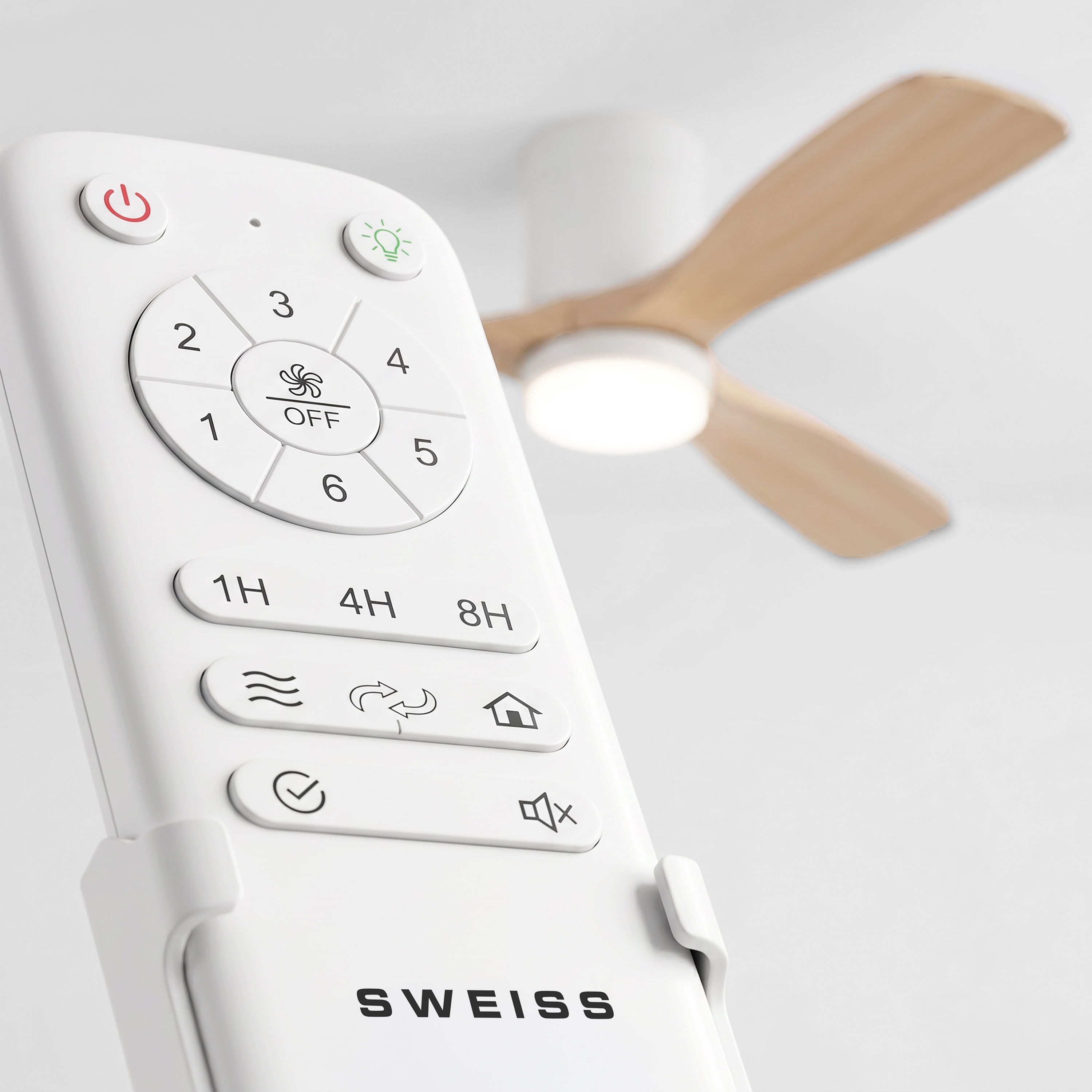 Un control remoto blanco con botones redondos en primer plano y un ventilador de techo de aspas de madera al fondo.