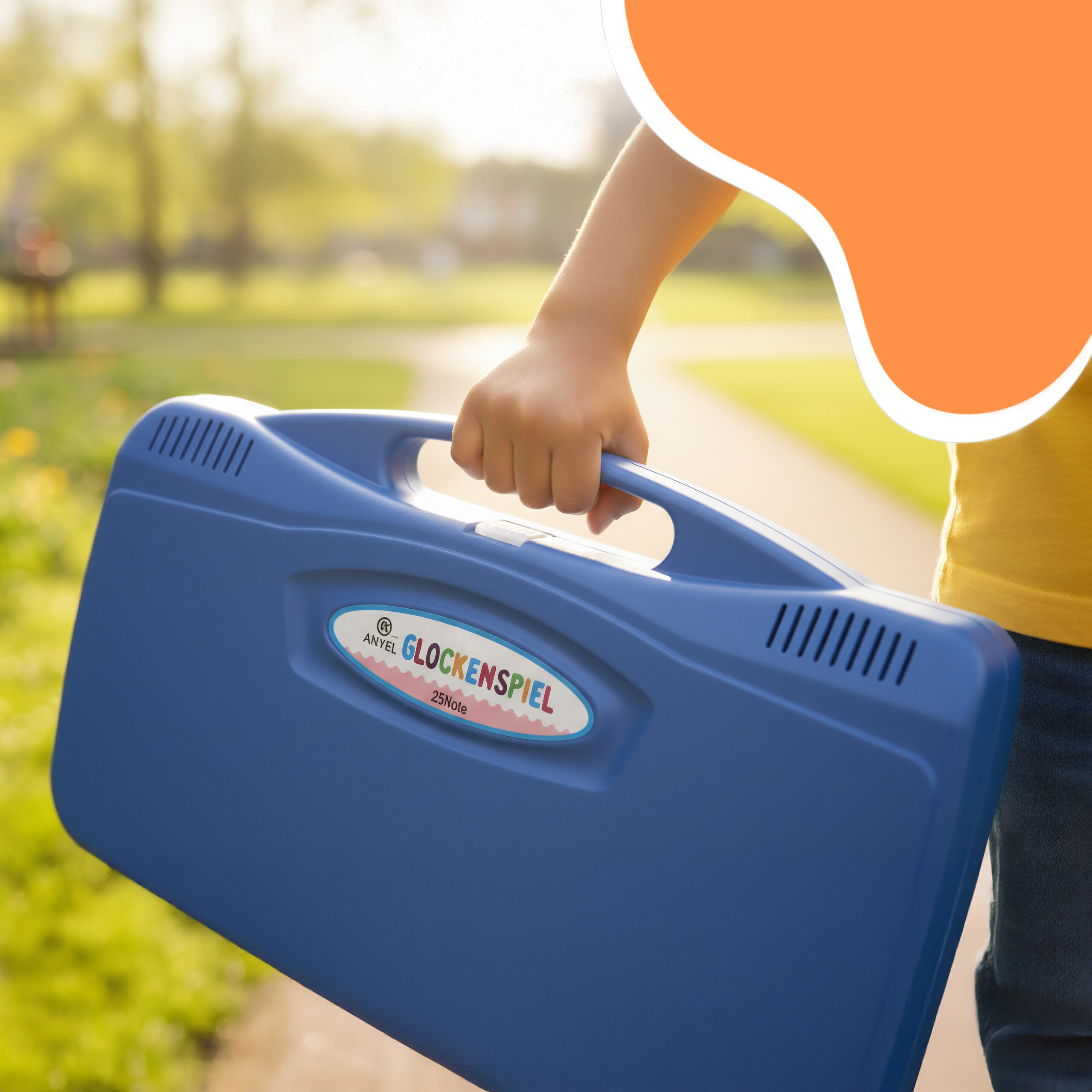 Ein Kind hält einen blauen Glockenspielkasten in einem sonnigen Park.