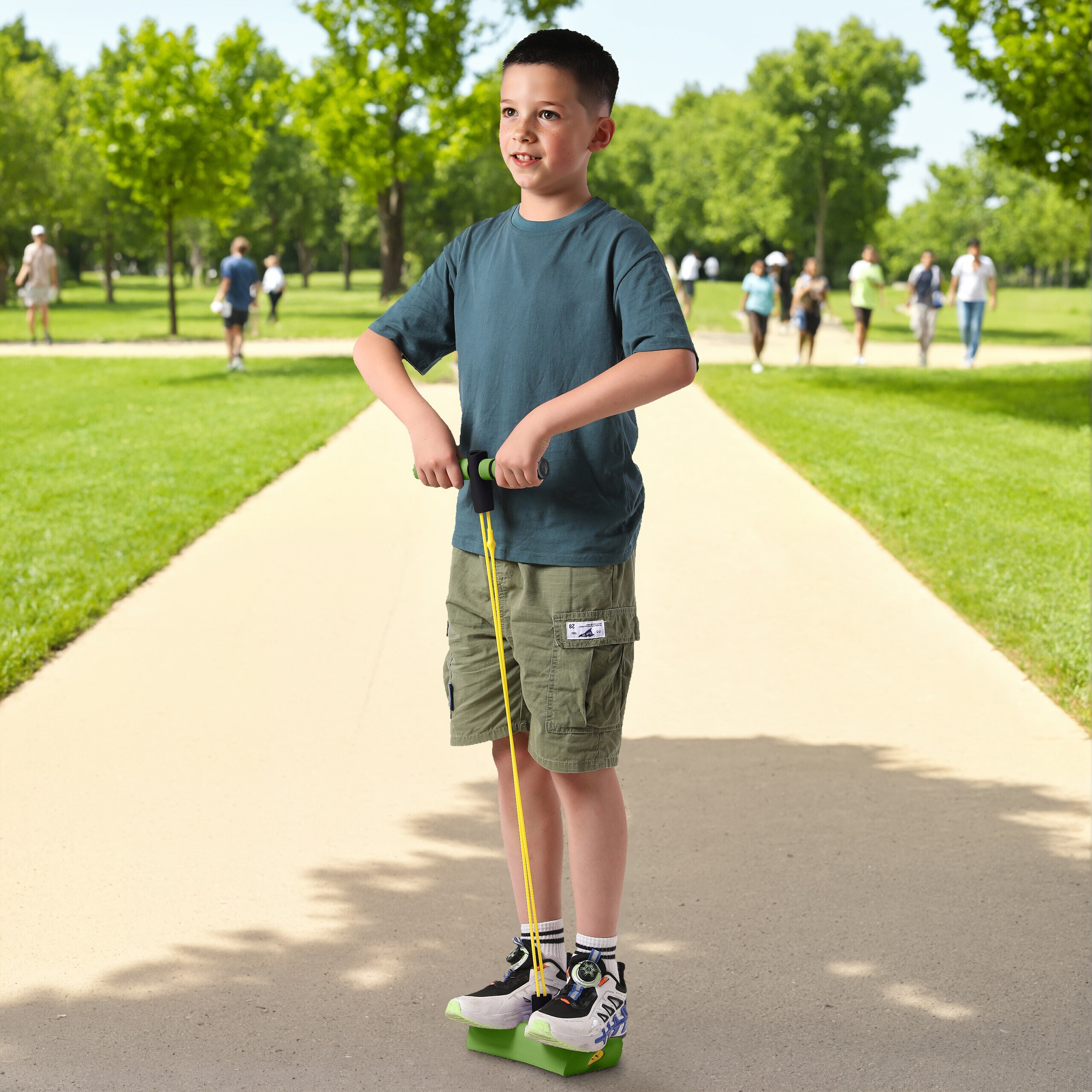 Ein Junge in einem grünen T-Shirt und Shorts steht auf einem Pogo-Stick auf einem Weg im Park.