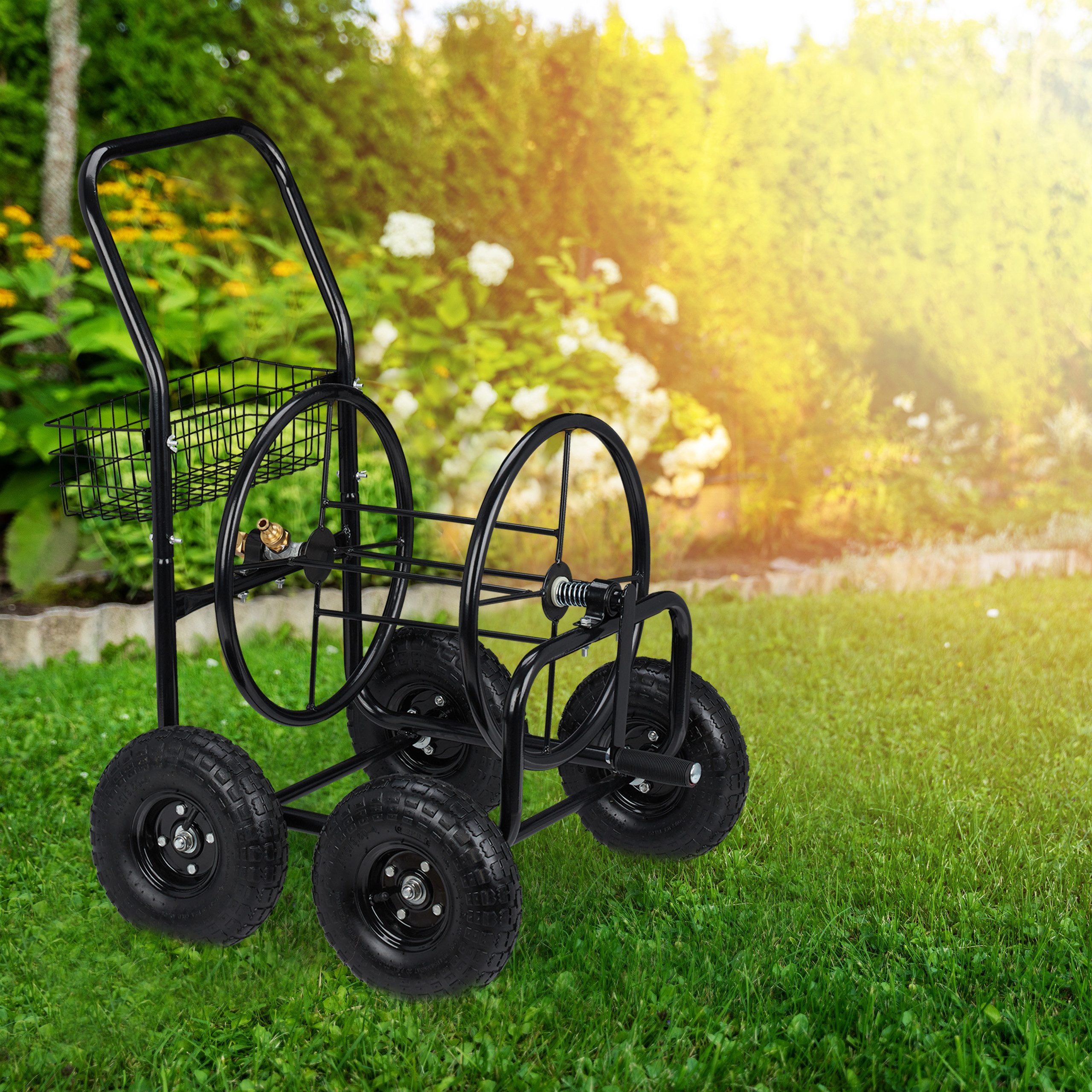 Ein schwarzer Gartenschlauchwagen aus Metall steht auf grünem Gras.