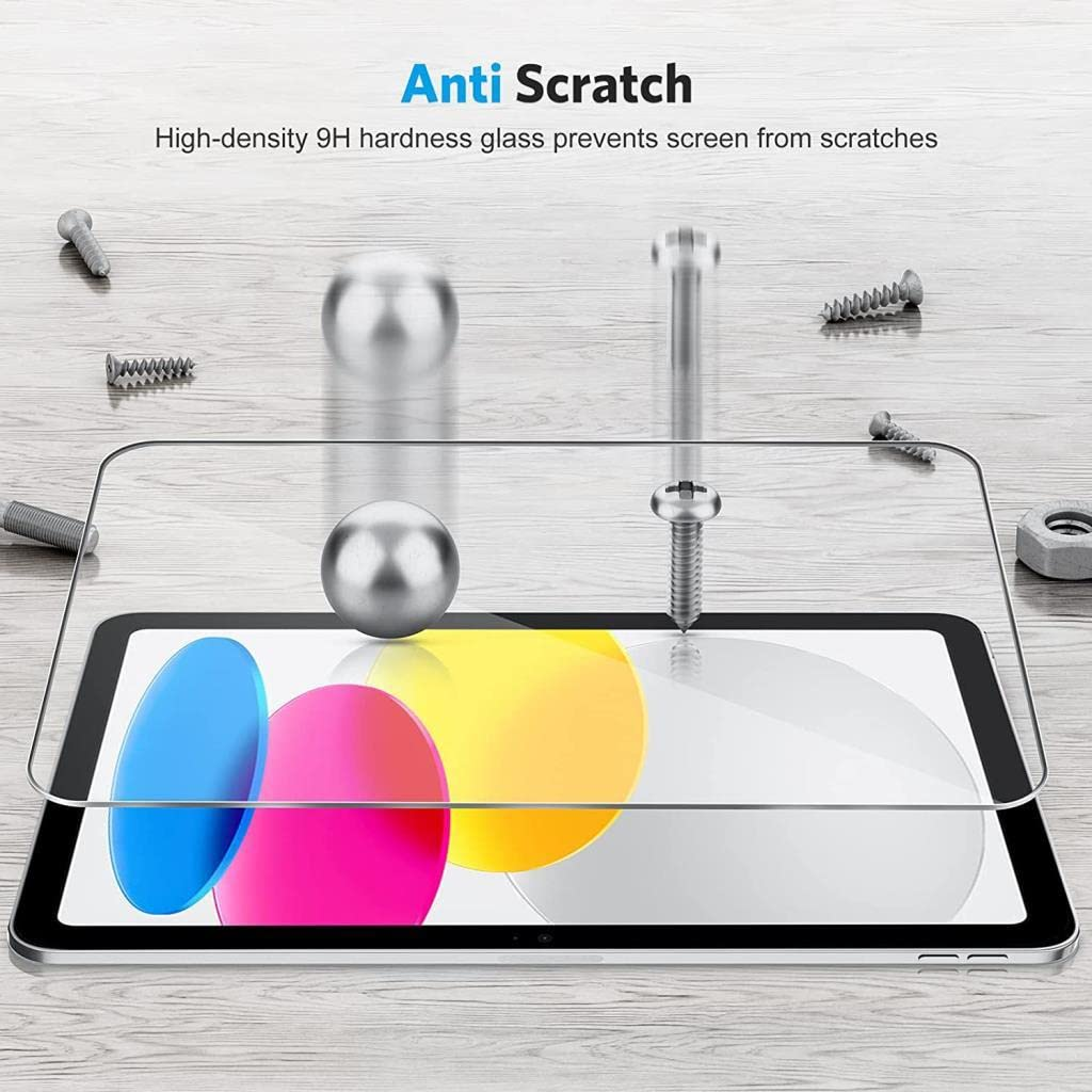 Ahşap arka planda düşen metal bilye ve vida ile tablet ekranı üzerinde çizmeyen cam koruyucu.