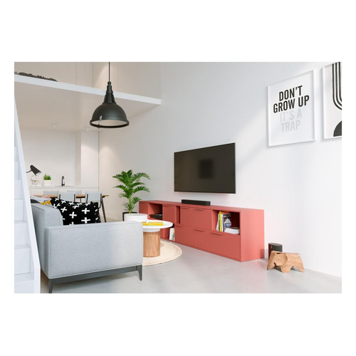 Salón con sofá, televisor, mueble rojo, comedor al fondo y arte en la pared.
