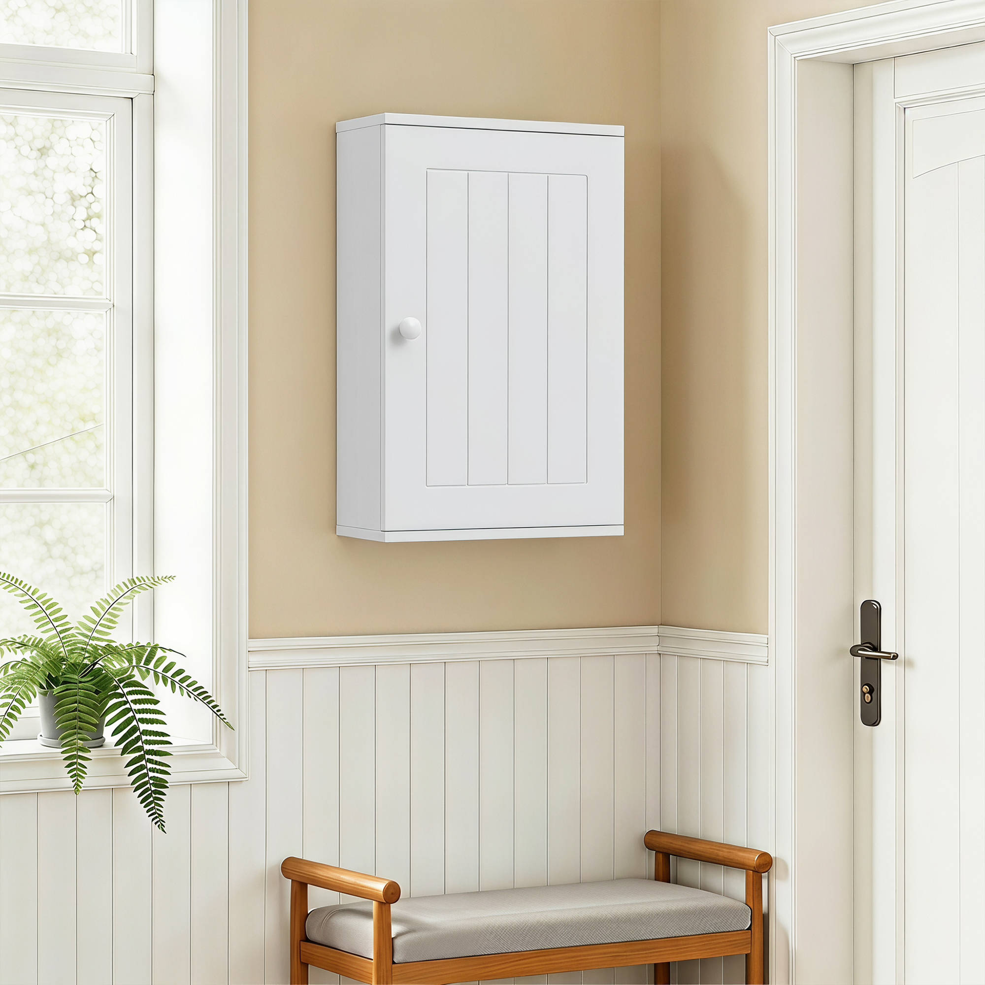 Un armario blanco cuelga sobre un banco de madera, junto a una ventana con un helecho y una puerta blanca.