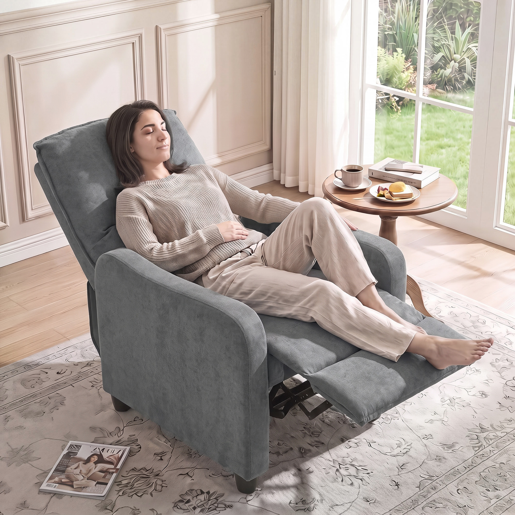 Una mujer se relaja con los ojos cerrados en un sillón gris en una habitación luminosa y moderna.