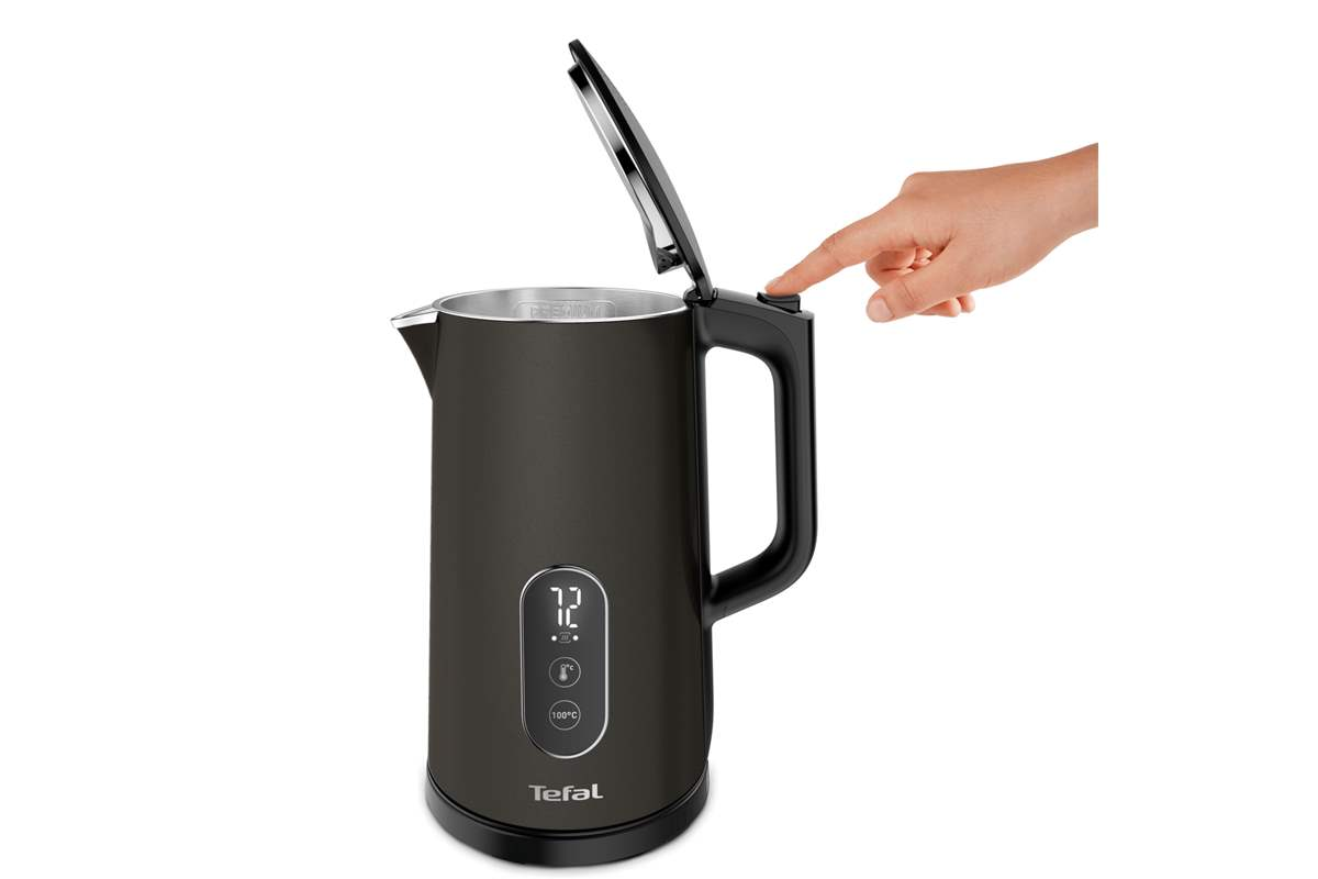 Una mano preme il pulsante di apertura del coperchio di un bollitore Tefal nero.