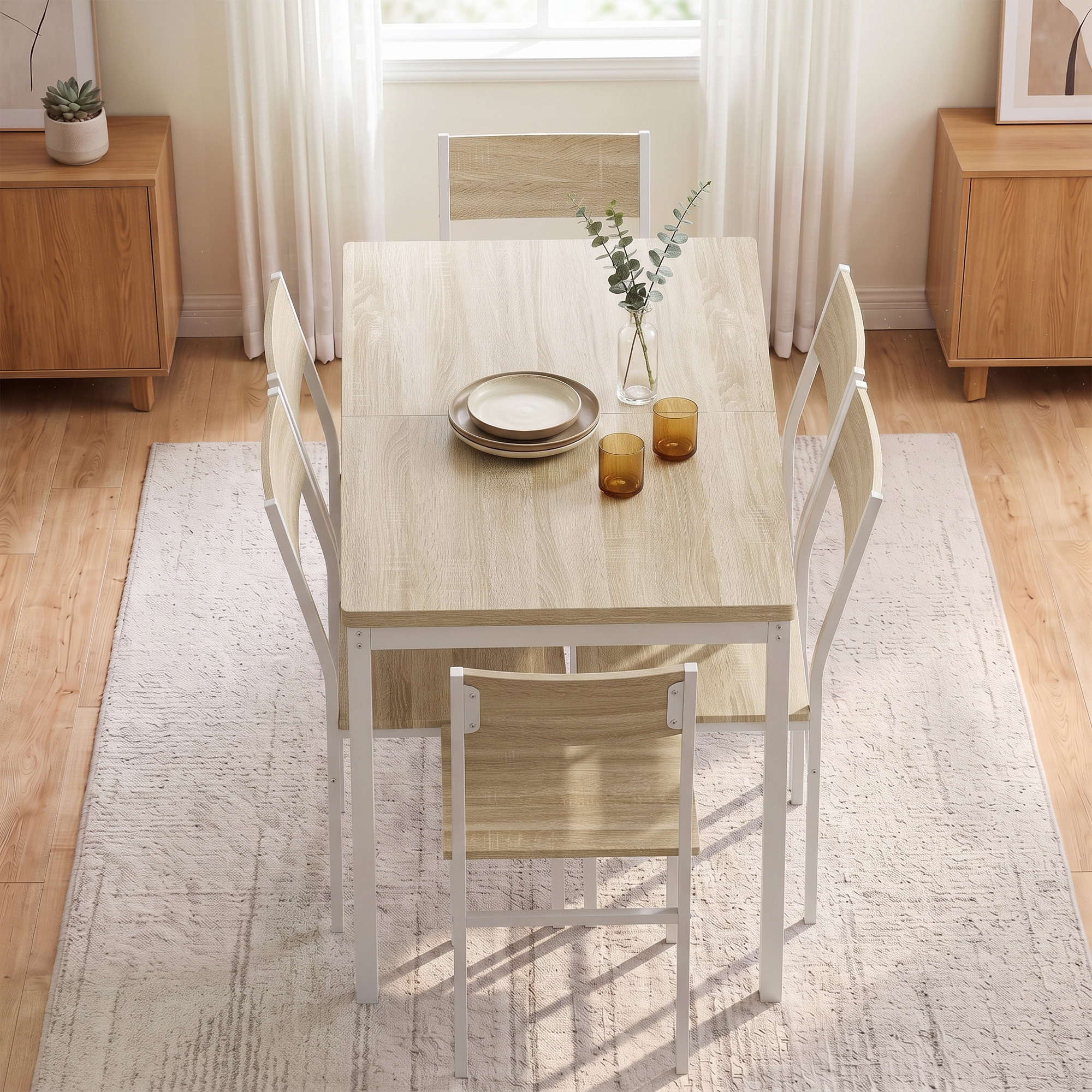 Una mesa de comedor de madera con cuatro sillas sobre una alfombra en una habitación con suelos de madera.