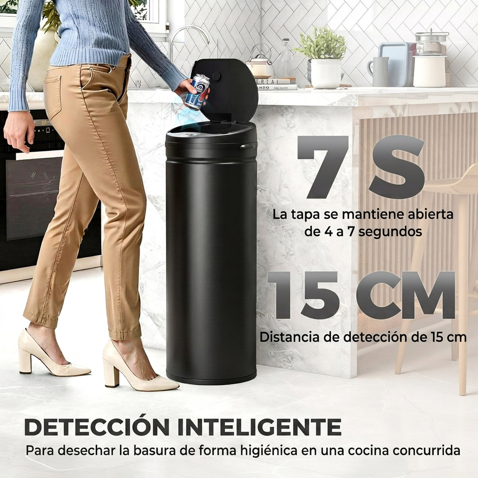 Una mujer tira una lata en un cubo de basura automático negro en una cocina luminosa.