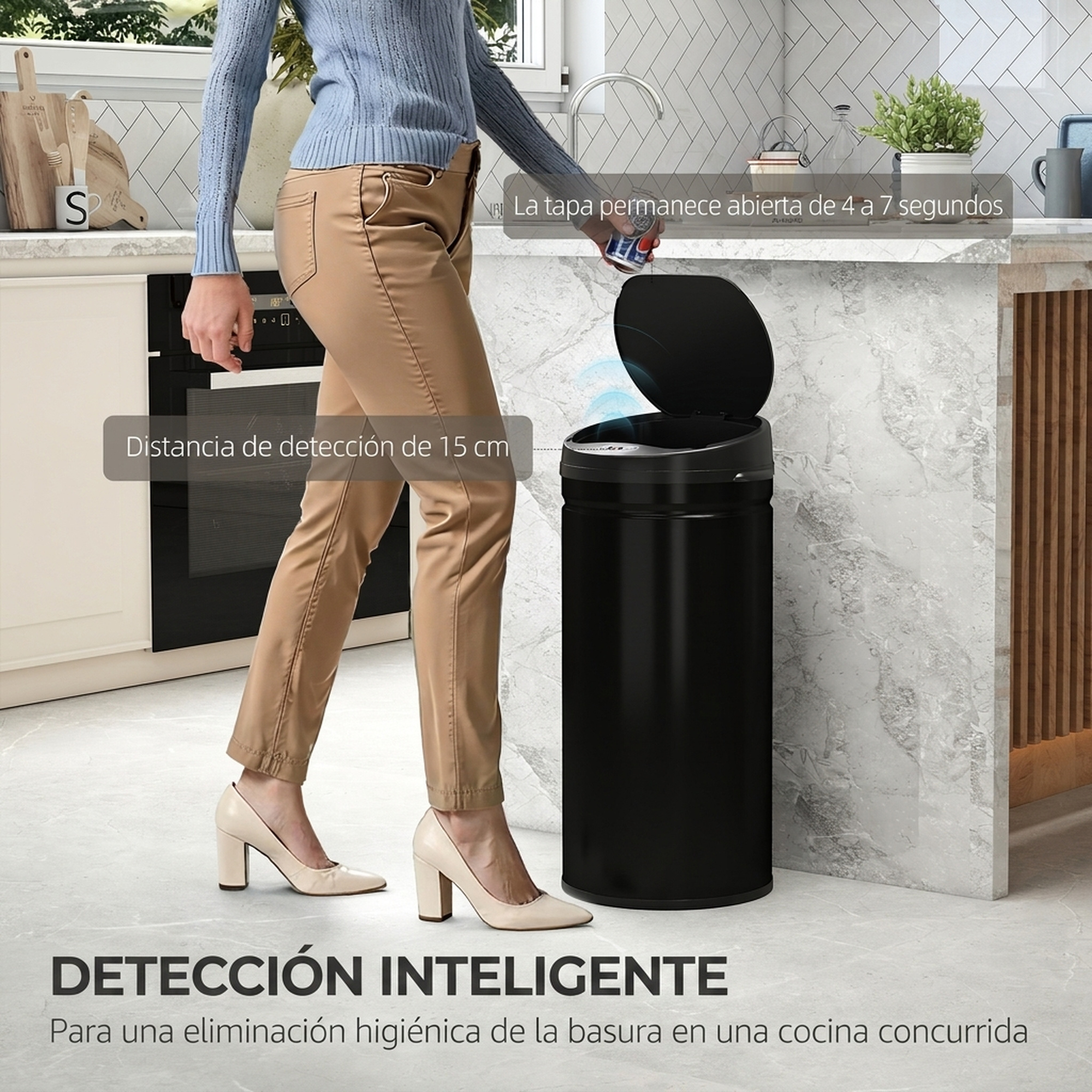 Una mujer en una cocina moderna tira una lata en un basurero automático con tapa abierta.