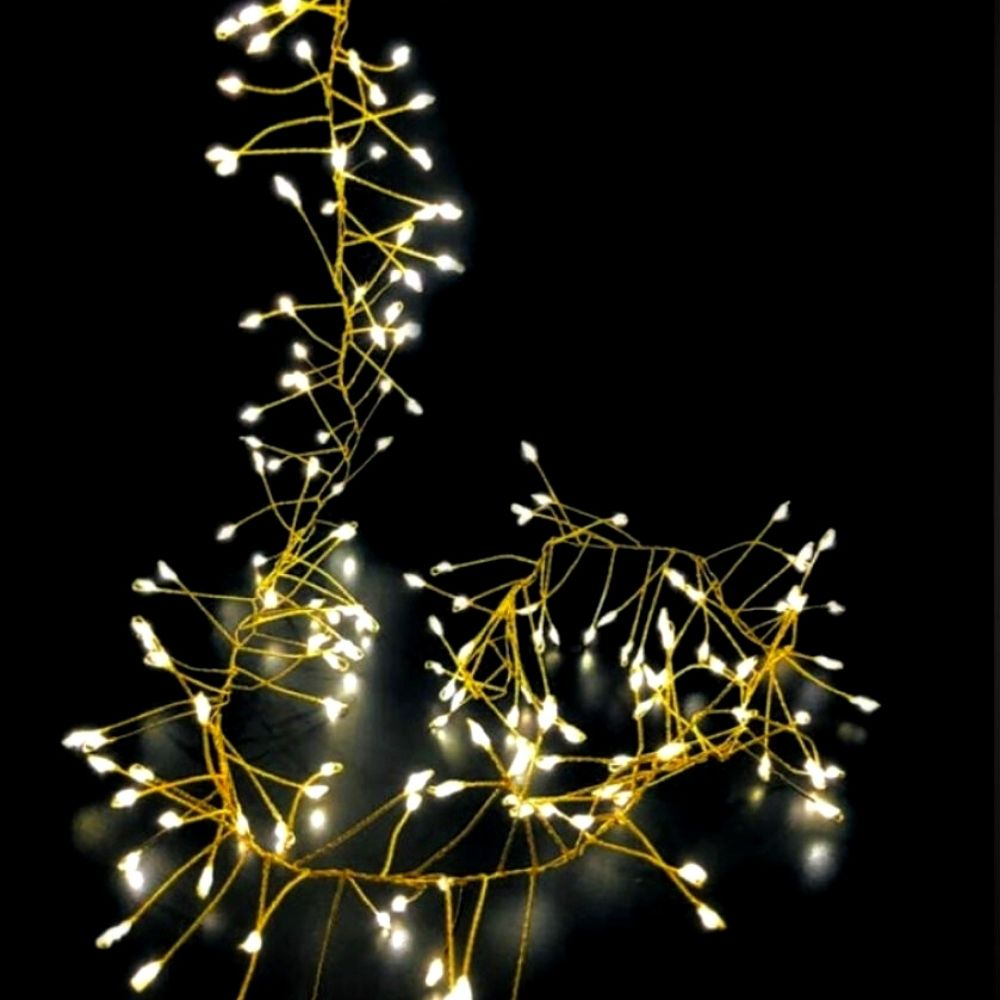 Cadena de luces brillantes con pequeños LED blancos cálidos sobre fondo oscuro.