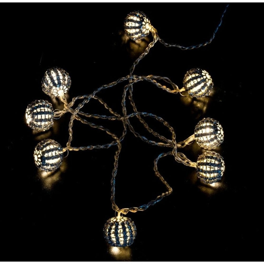 Una cadena de luces decorativas con bombillas esféricas azules y plateadas brillantes sobre fondo negro.