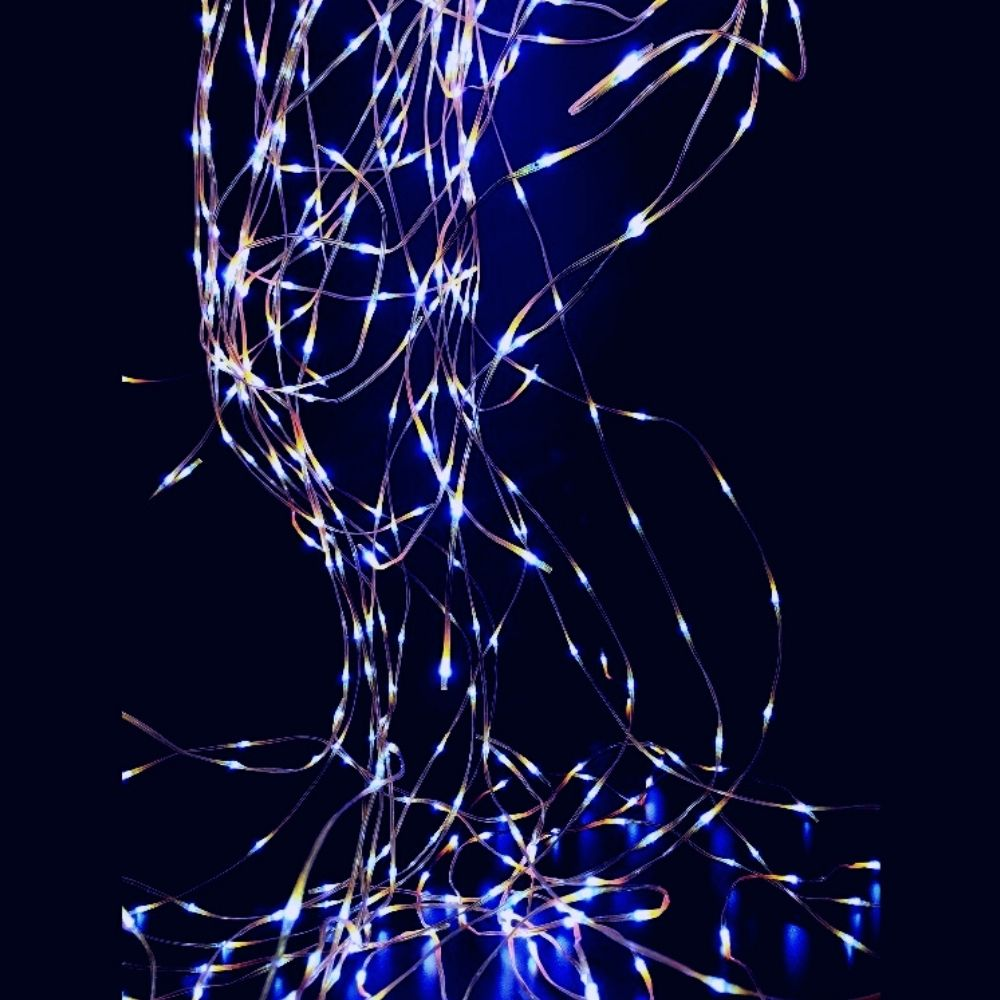 Luces de hadas enredadas con LED azules y blancos brillan contra un fondo oscuro.