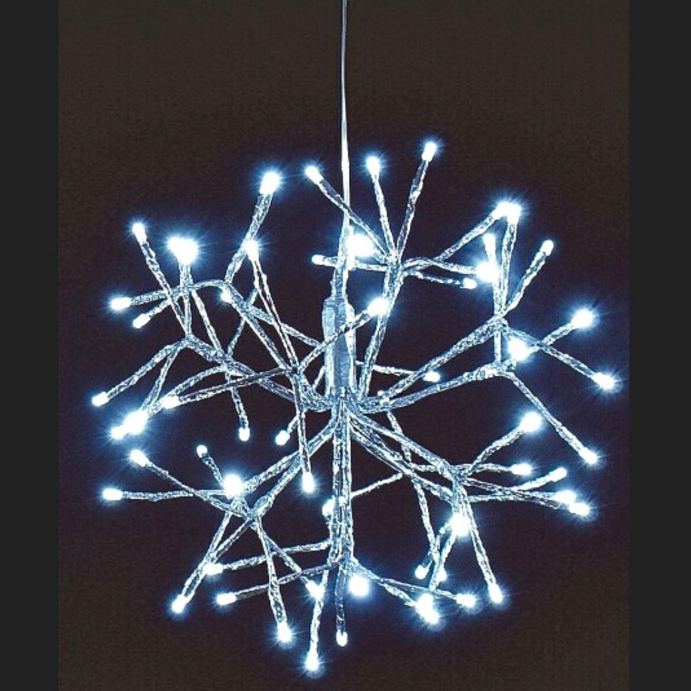 Una luz LED colgante con forma de estructura brillante similar a un copo de nieve sobre un fondo oscuro.