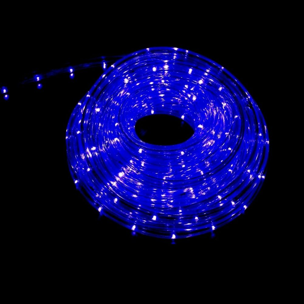 Un rollo de luces LED de cuerda azul brillante brilla sobre un fondo negro oscuro.