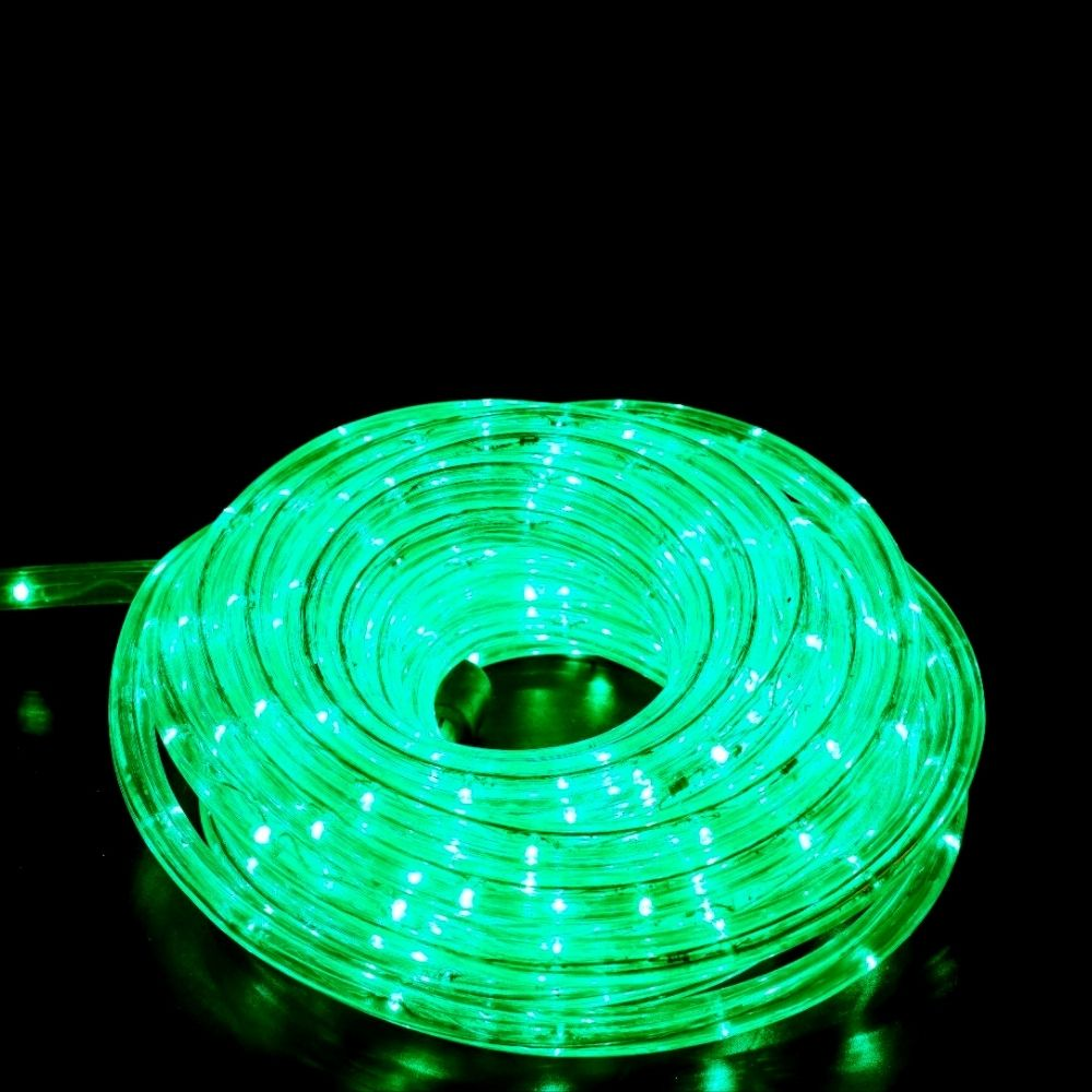 Una cadena de luces enrollada brilla en verde brillante sobre un fondo negro.