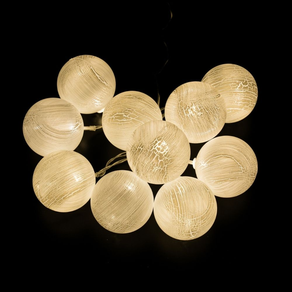 Una cadena de diez luces esféricas y brillantes con textura agrietada sobre fondo negro.