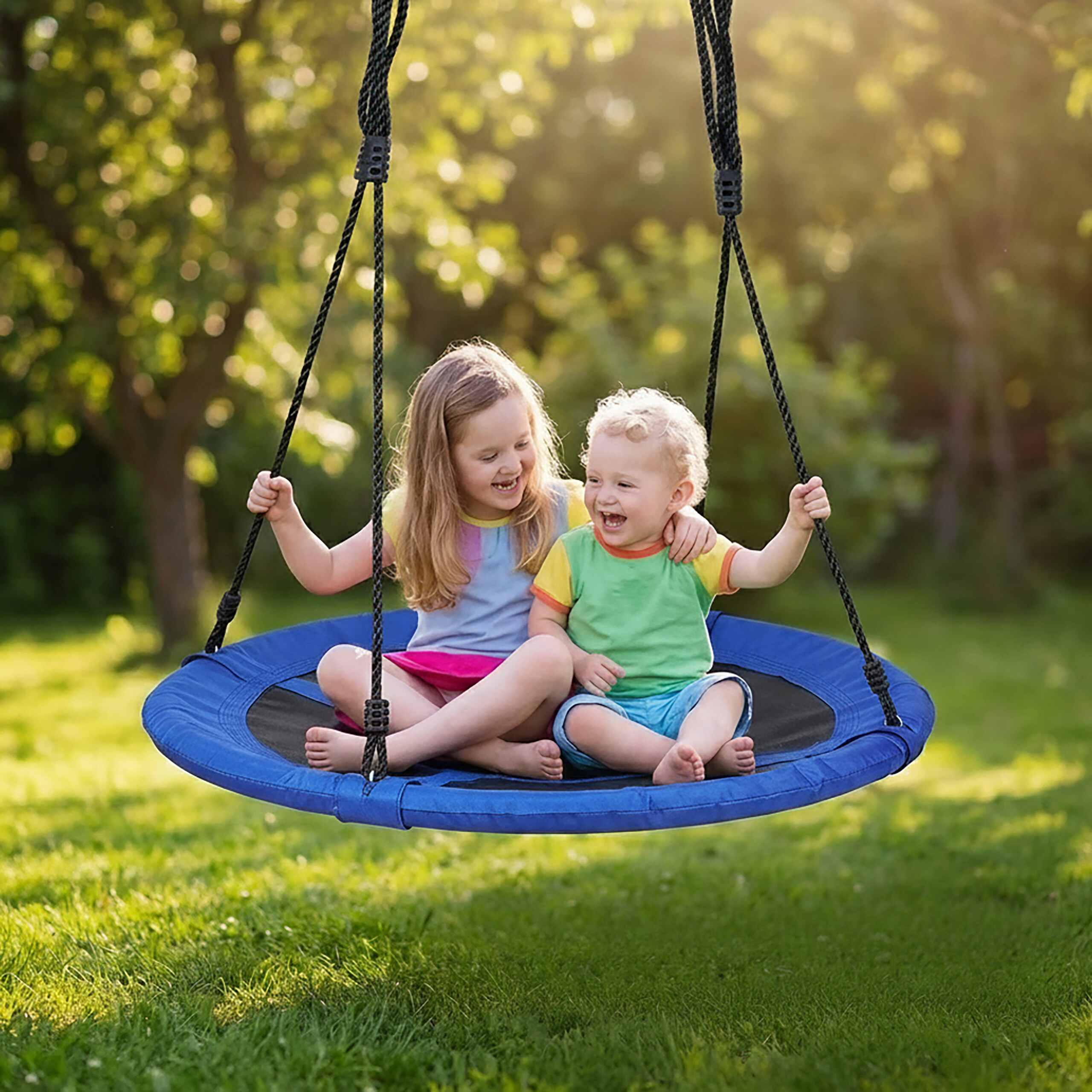 Zwei lächelnde Kinder spielen zusammen auf einer blauen Schaukel im sonnigen Garten.