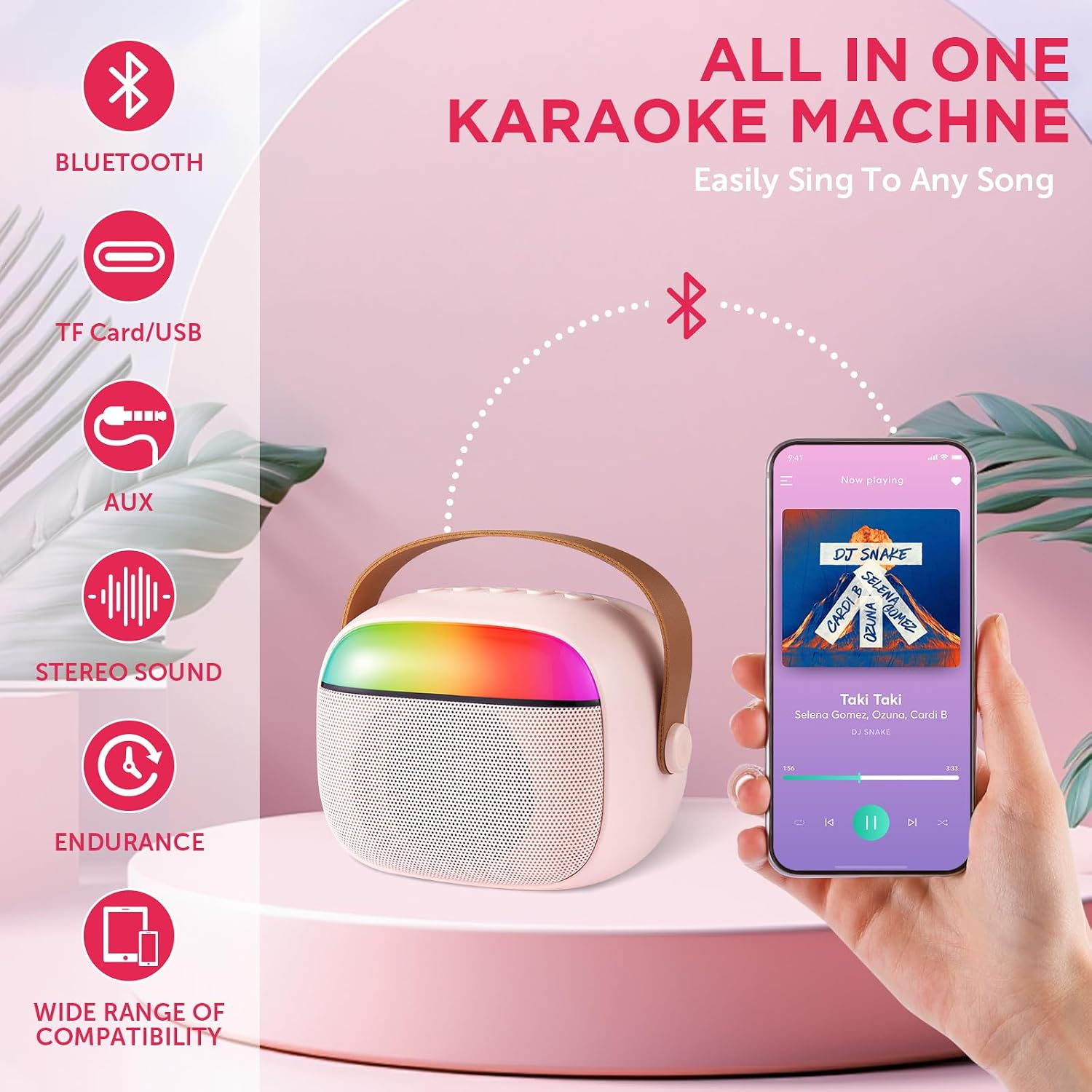 Eine rosa Karaoke-Maschine mit Regenbogenlicht, Ledergriff und Smartphone mit Musik-App  über Bluetooth.