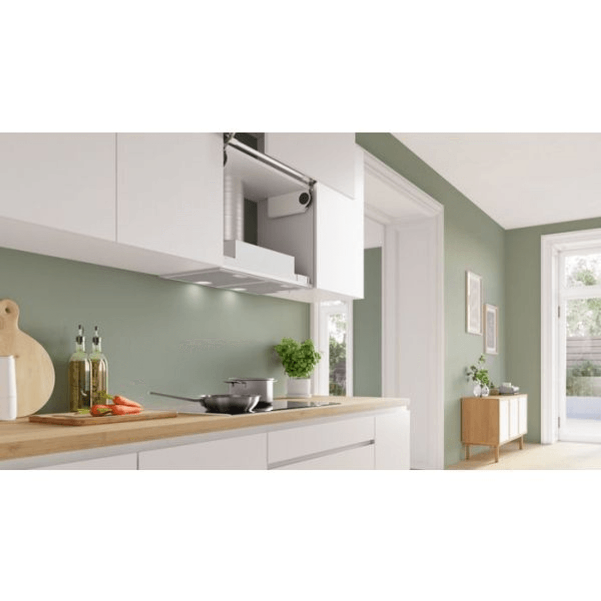 Una cocina moderna tiene gabinetes blancos, pared verde, encimera de madera con sartén y un mueble.