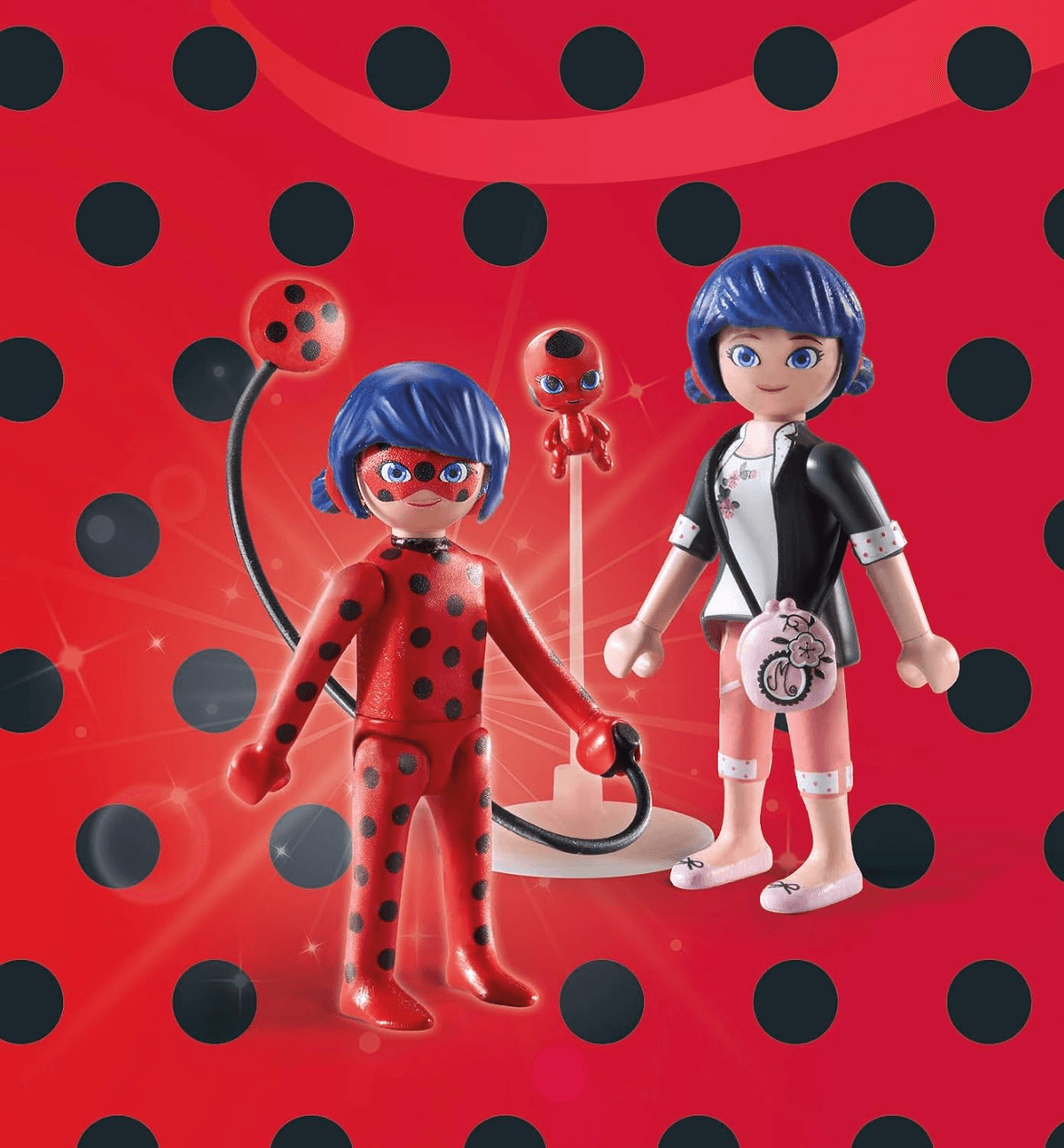 Dos figuras de Playmobil de Ladybug y Marinette se encuentran frente a un fondo rojo con puntos negros.