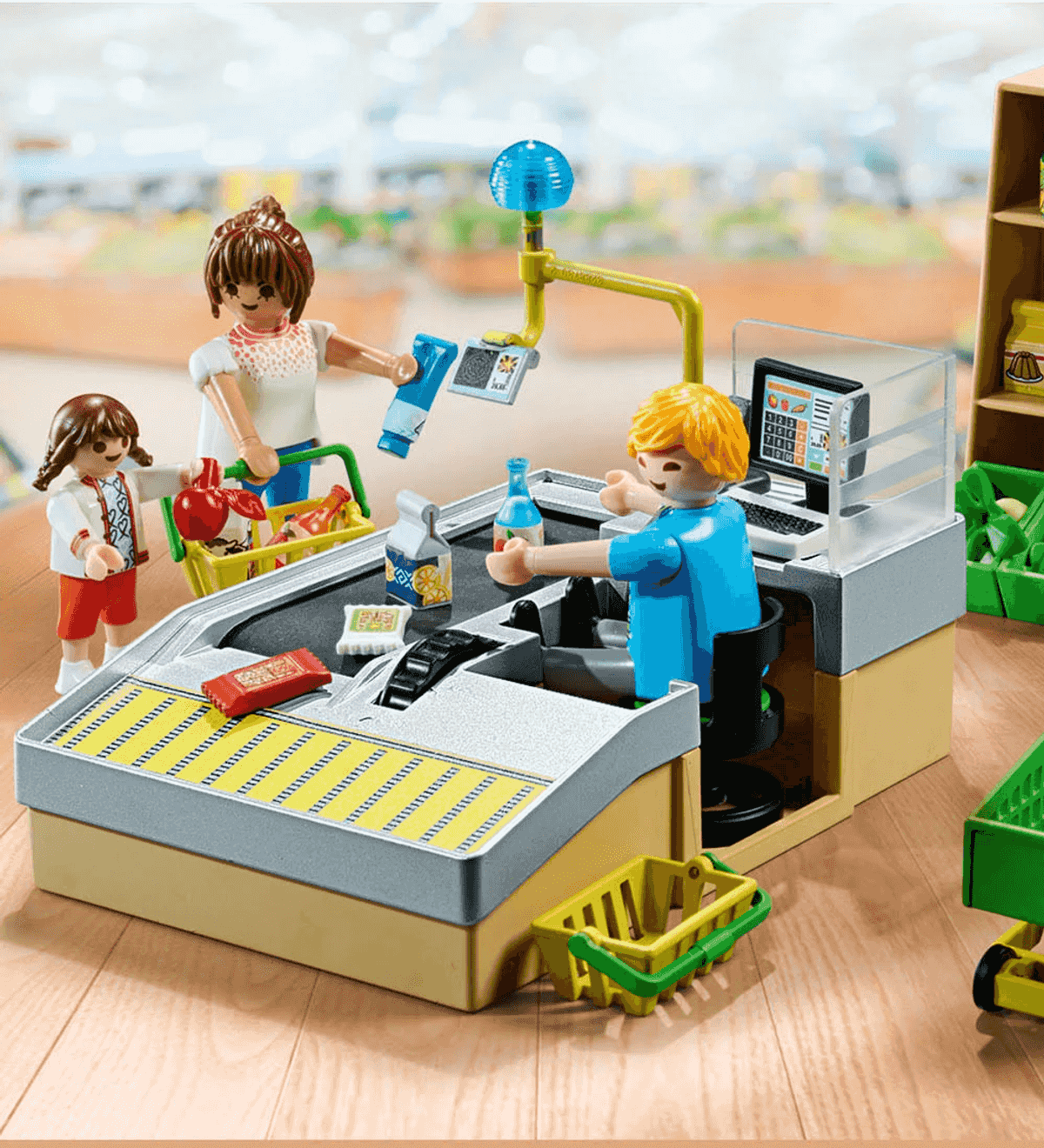 Caja de supermercado Playmobil con figuras, cinta transportadora, escáner y comestibles en suelo de madera.
