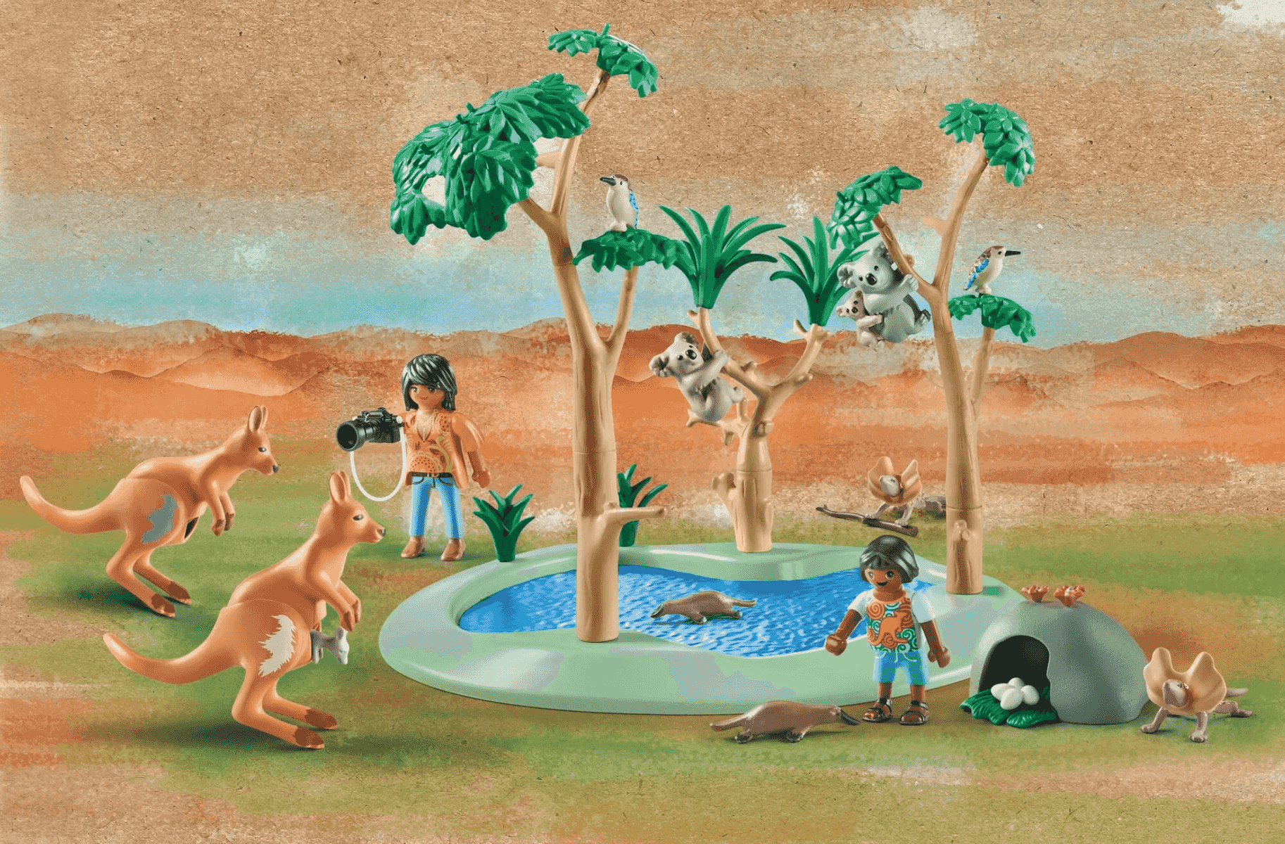 Playmobil-Szene in Australien mit zwei Figuren, Kängurus, Koalas und Tieren an einem Wasserloch.