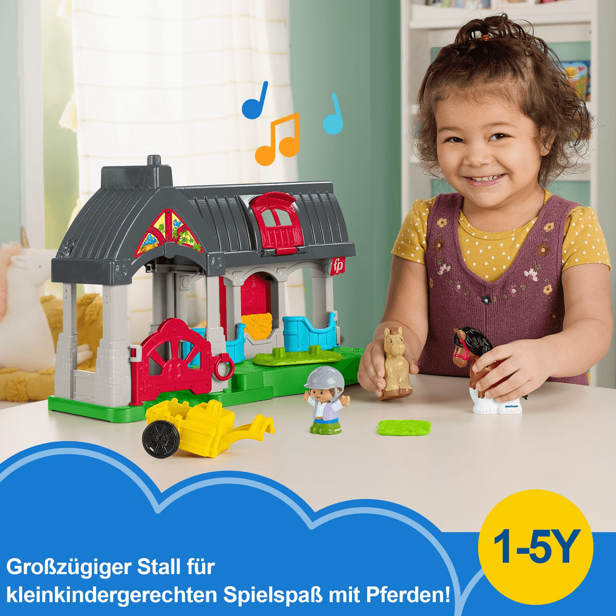 Ein smiling Mädchen spielt mit einem Spielzeugstall, Figuren und Pferden auf einem Tisch.