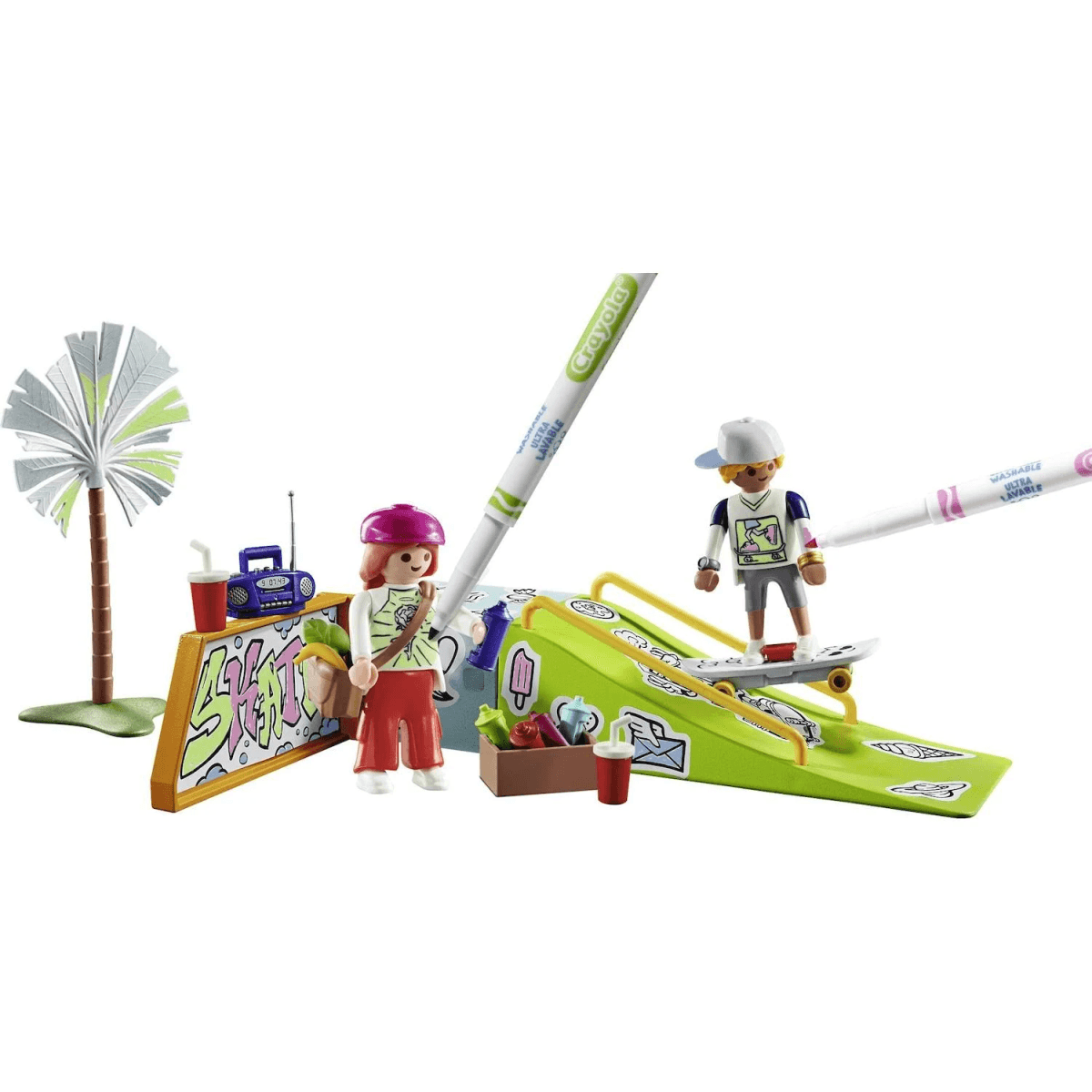 Escena de parque de skate de Playmobil con dos figuras, una rampa verde, un muro de grafiti y dos rotuladores Crayola gigantes.