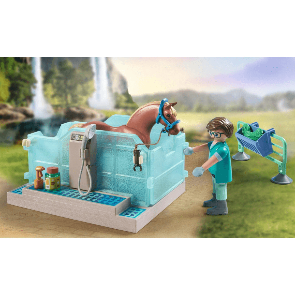 Eine Spielfigur wäscht ein braunes Spielzeugpferd in einer blauen Wanne vor einer Bergkulisse.