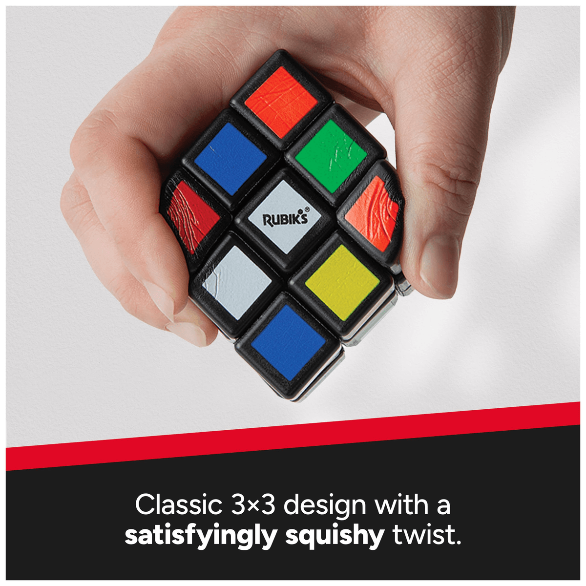 Una mano aprieta un cubo de Rubik blando contra un fondo blanco y negro.