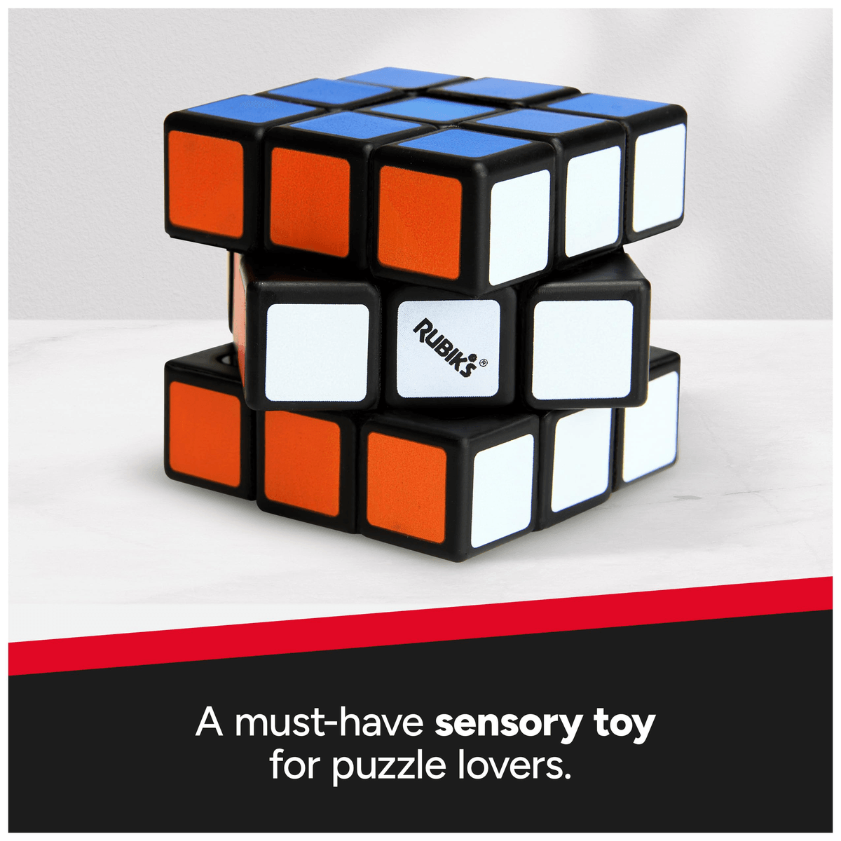 Un cubo de Rubik con caras naranjas, blancas y azules sobre una superficie blanca, con texto abajo.