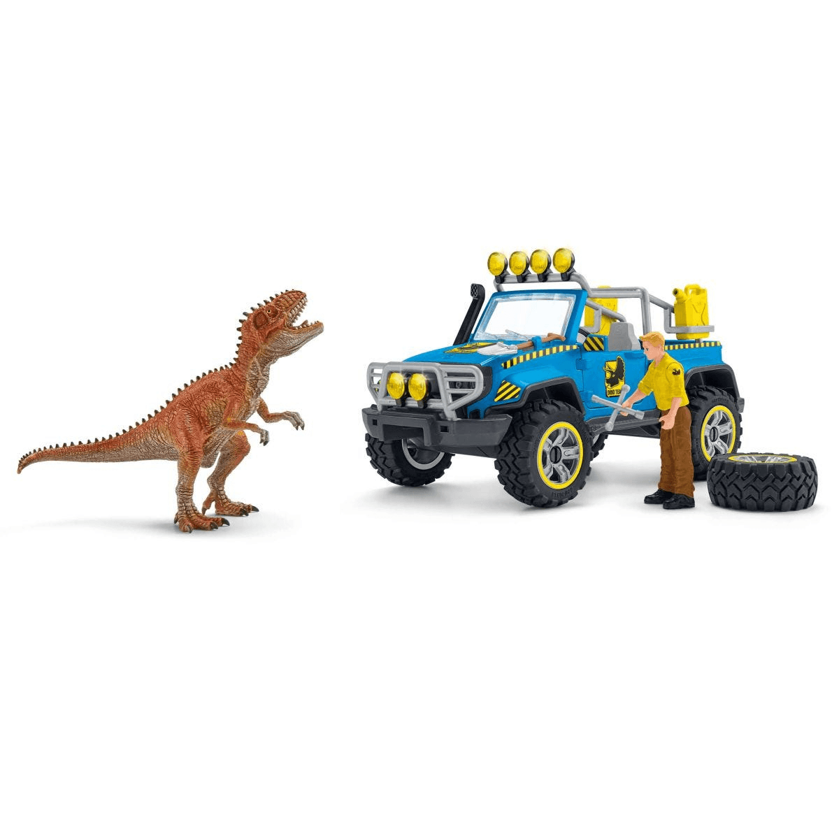 Un dinosaurio de juguete se enfrenta a un todoterreno azul, junto al cual hay una figura y un neumático.