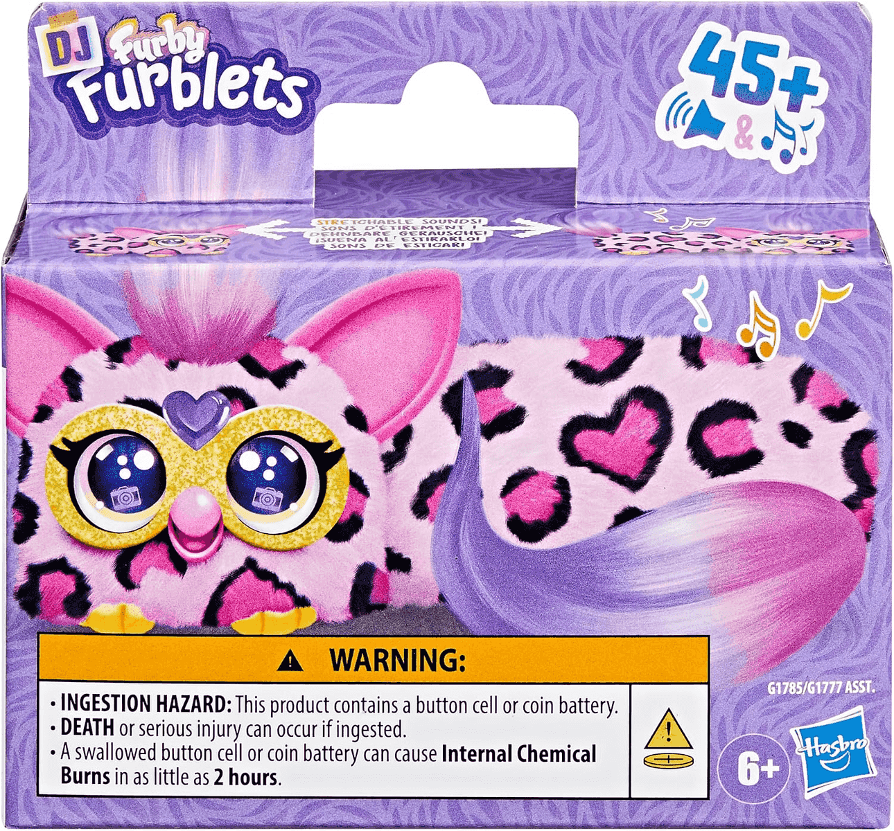 Empaque morado de un juguete DJ Furby Furblets con estampado de leopardo rosa, ojos grandes y advertencia abajo.