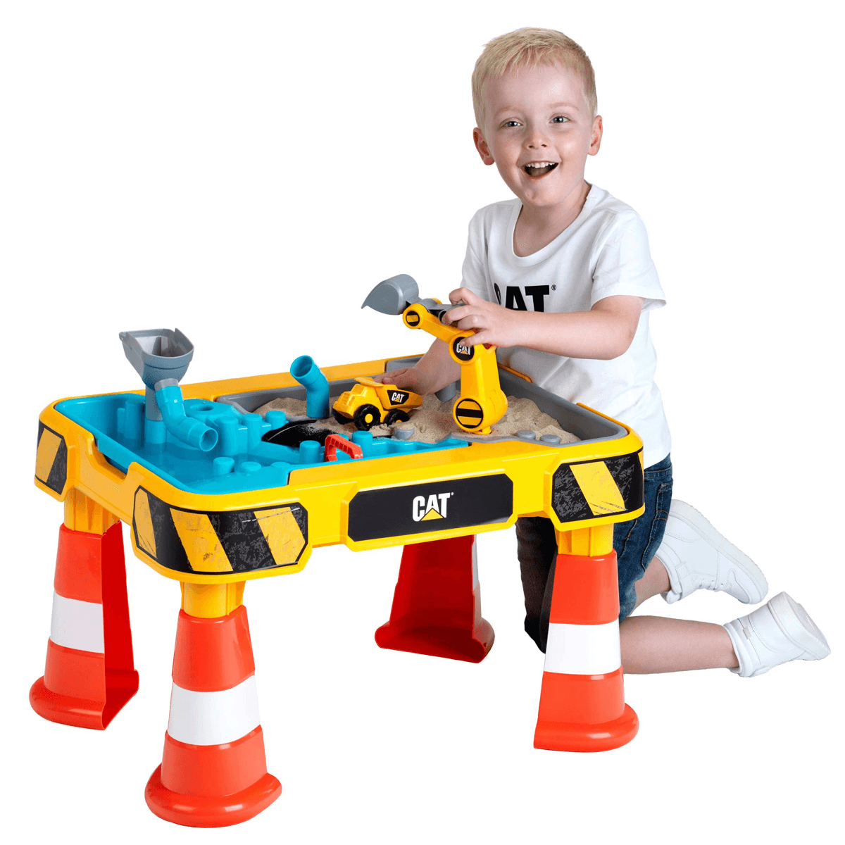 Un niño feliz juega con una mesa de arena y agua CAT, con camiones y conos de juguete.