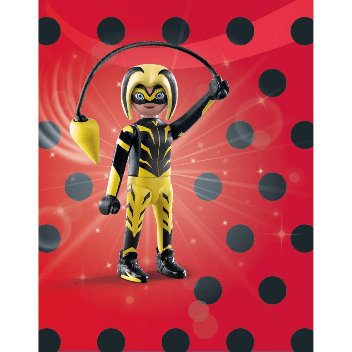 Una figura de juguete con traje de abeja amarillo y negro sobre fondo rojo con puntos.