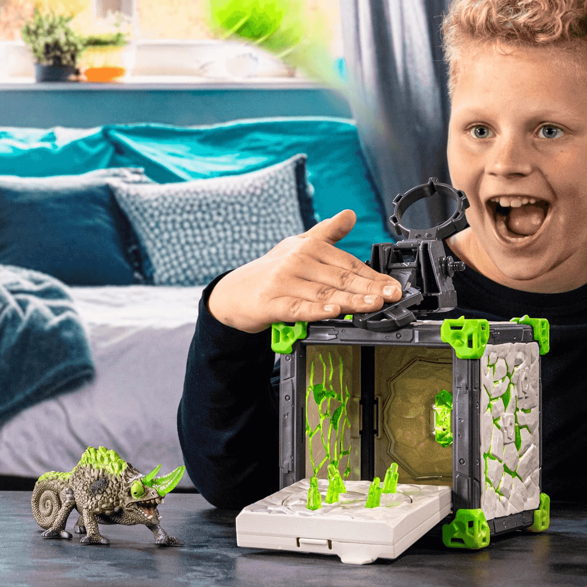 Un niño se emociona mientras juega con un cubo de juguete y una figura de dinosaurio.