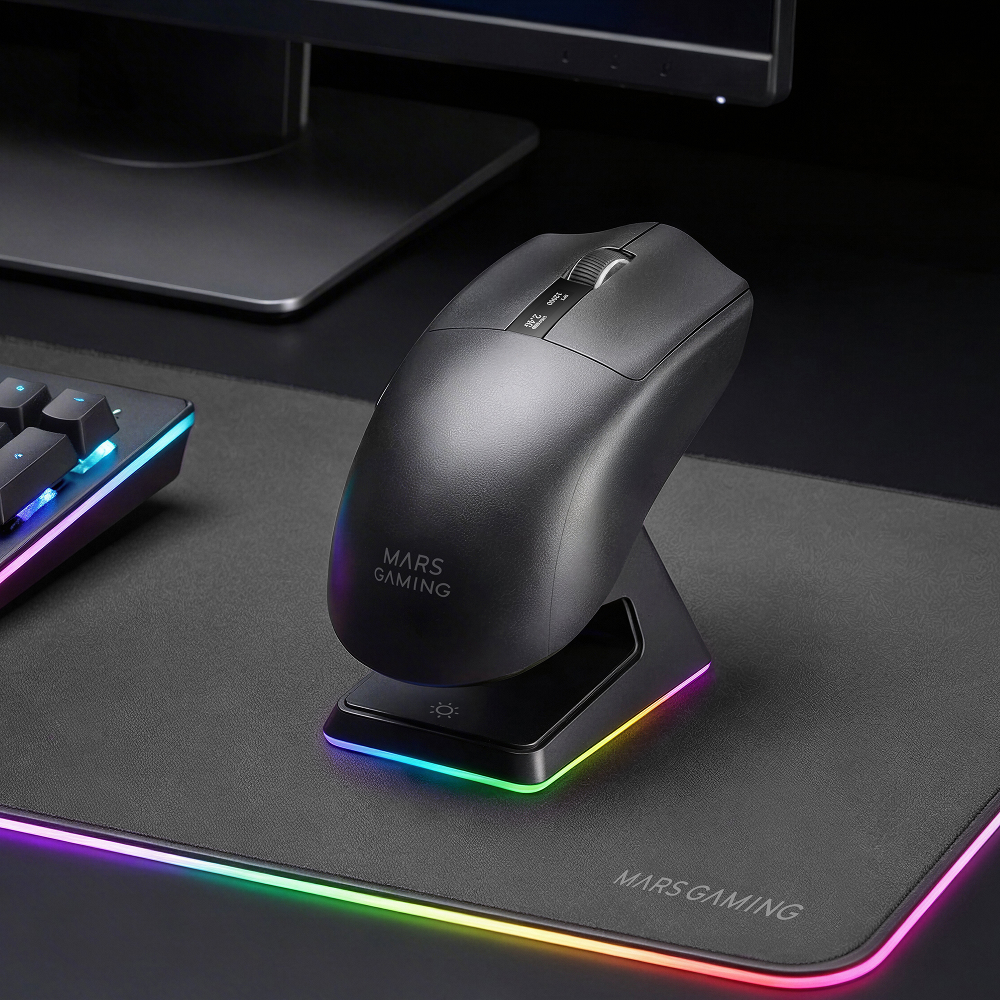 Ratón negro Mars Gaming en soporte iluminado con alfombrilla y teclado en un escritorio.