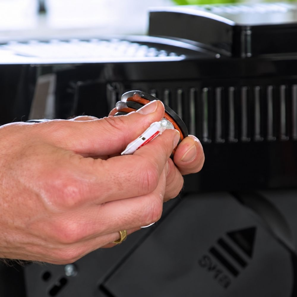 Person applies grease to a black seal with O-rings.