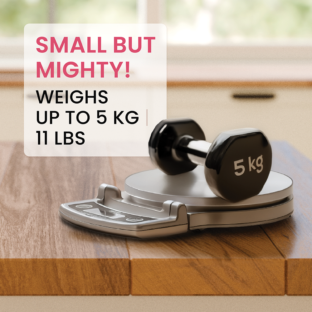 A small 5kg dumbbell rests on a digital kitchen scale on a wooden board.