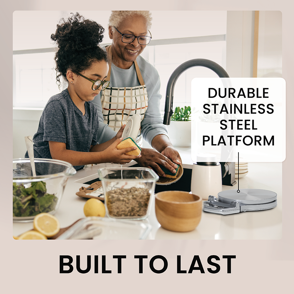 An older woman and a young girl wash dishes together next to a kitchen scale.