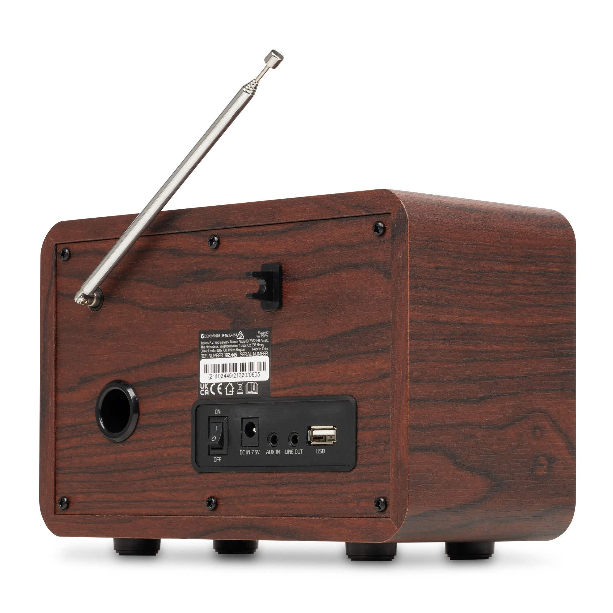 Vista trasera de una carcasa de radio de madera con antena, interruptor de encendido, entrada DC, AUX, salida de línea y USB.